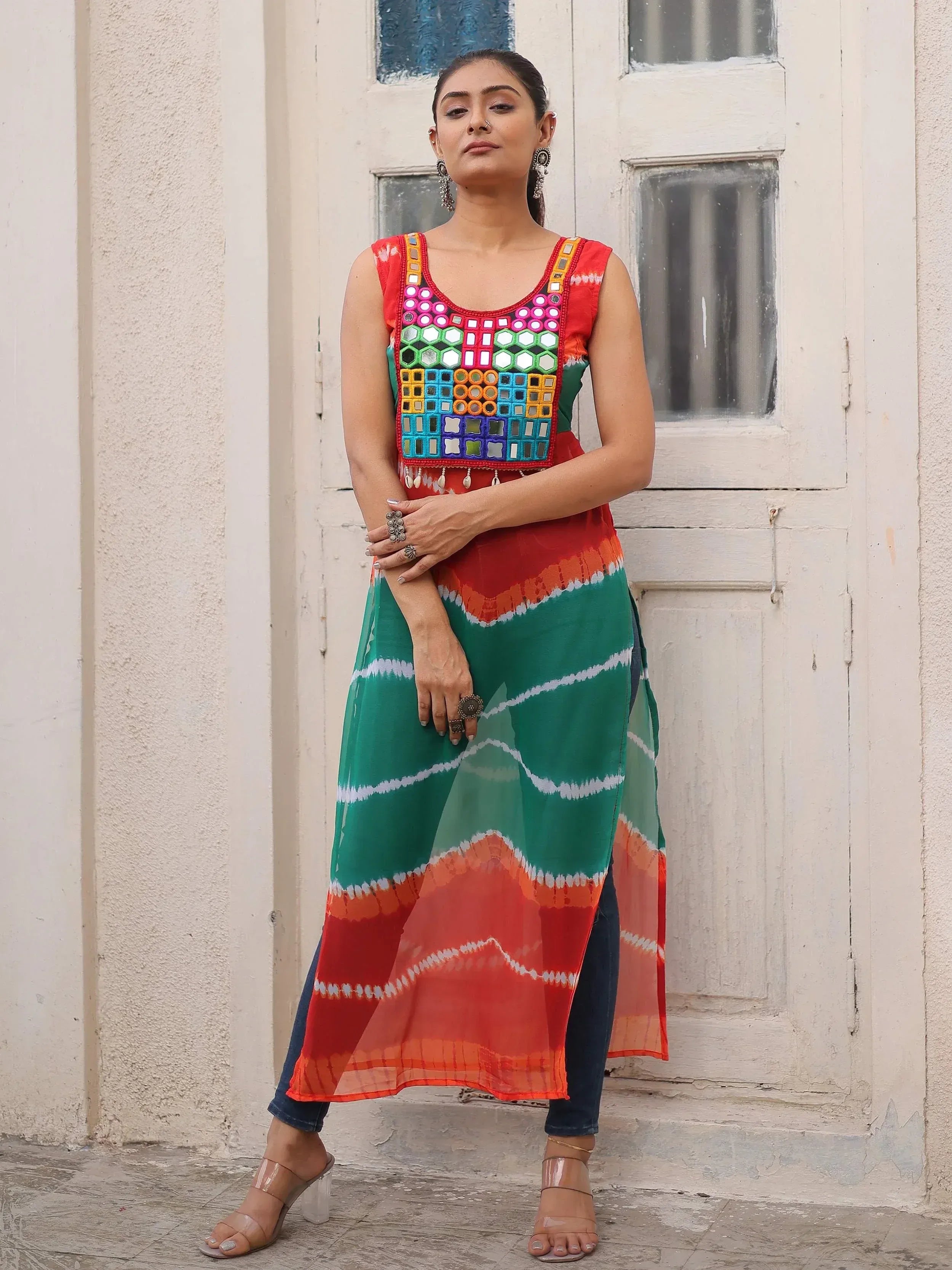 Colorful mirror work ethnic kurti with tie-dye print, paired with jeans for a fusion look.