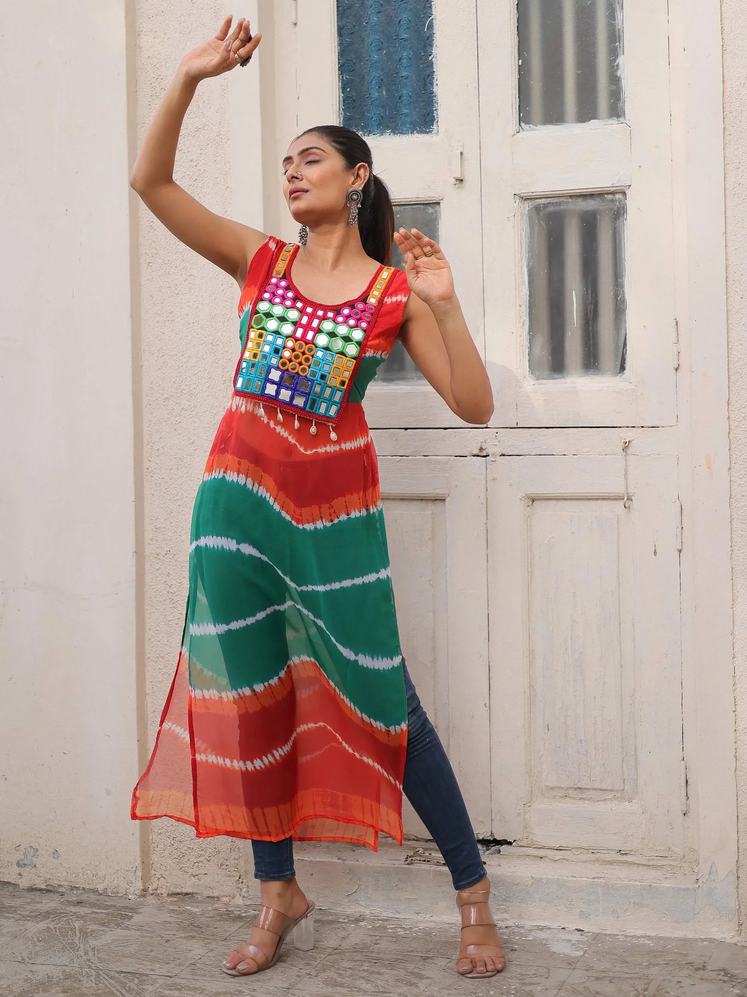 Woman in colorful mirror-work ethnic gown with tie-dye print, styled with jeans for fusion look