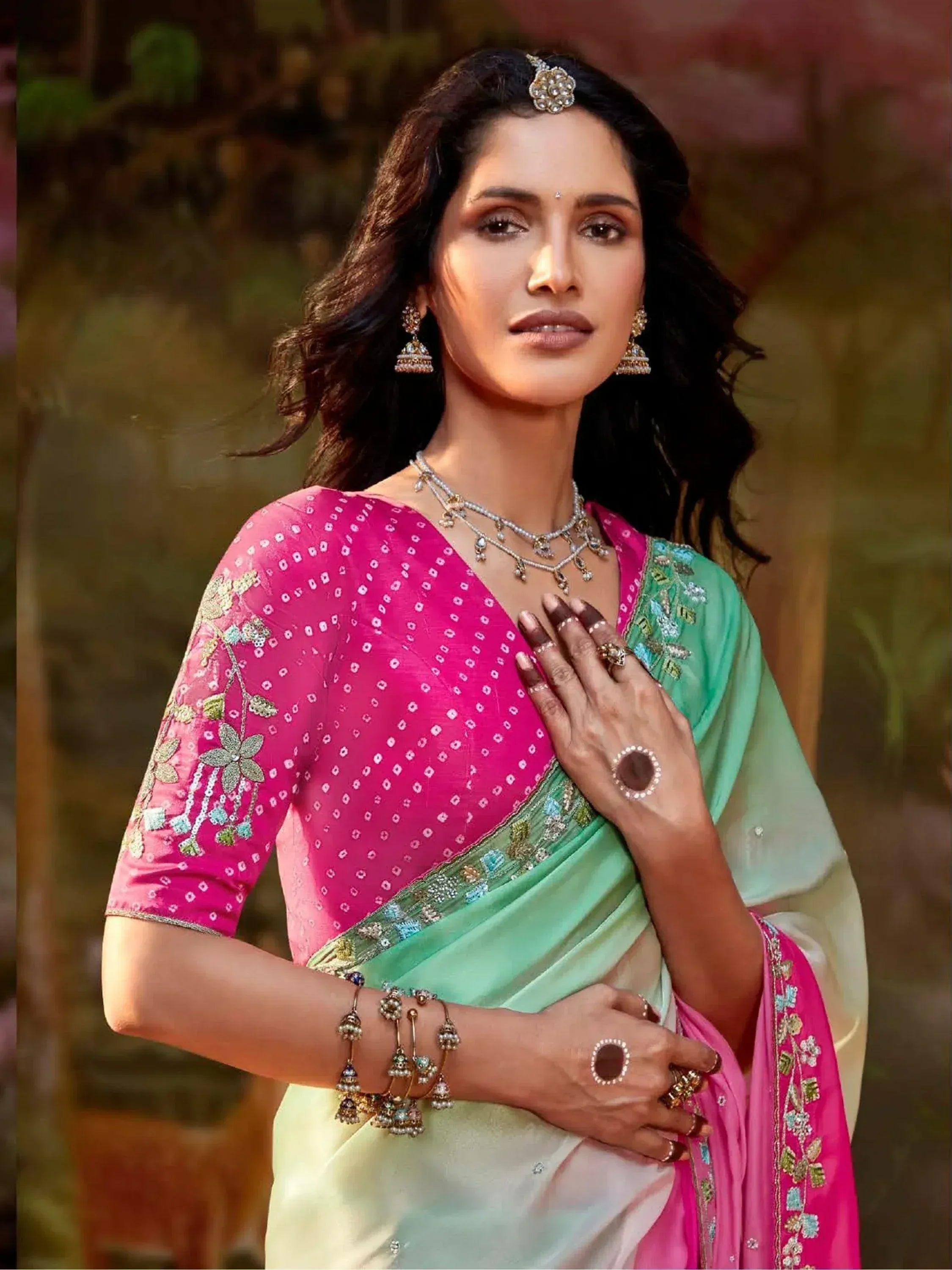 Woman in pink and mint green embroidered saree with traditional jewelry, perfect for Indian ethnic occasions