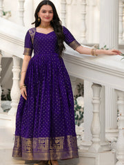 Woman in purple Indian ethnic gown with gold motifs, standing on white steps, Ethnic Plus