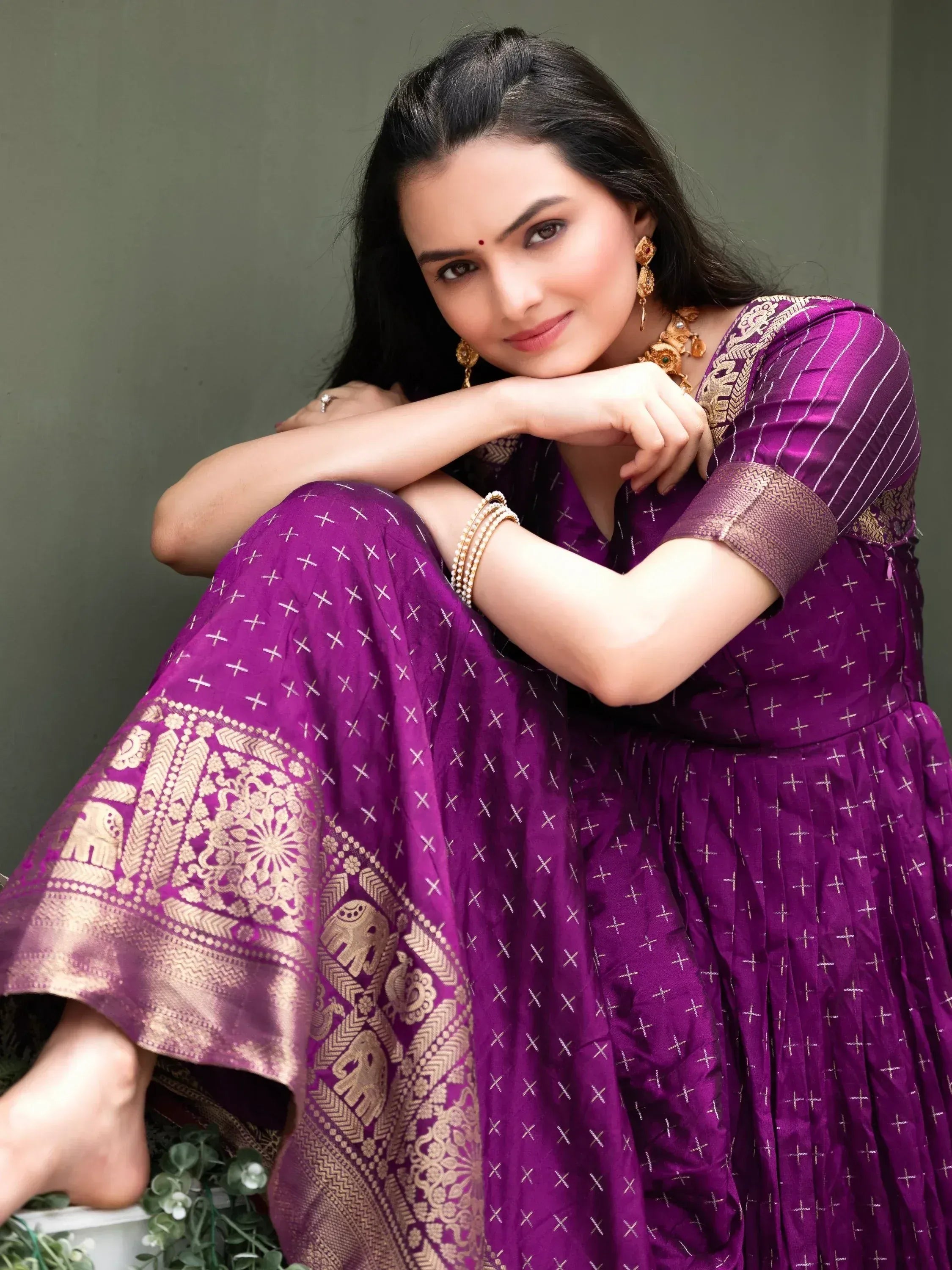 Woman in purple ethnic gown with gold elephant print, perfect for Indian occasions and festive wear.