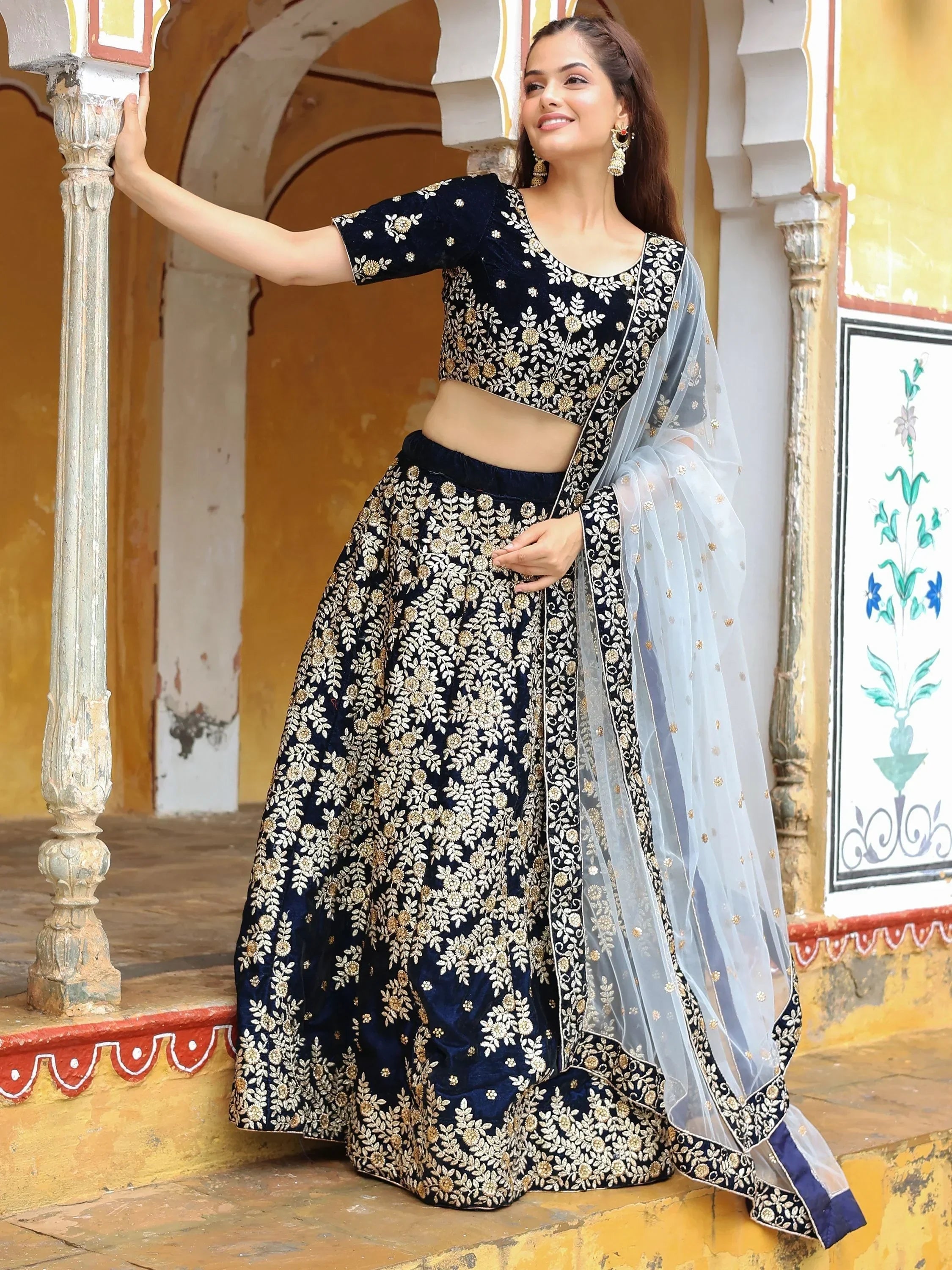 Navy blue velvet lehenga choli with gold floral embroidery and sheer dupatta, perfect for Indian ethnic wear occasions