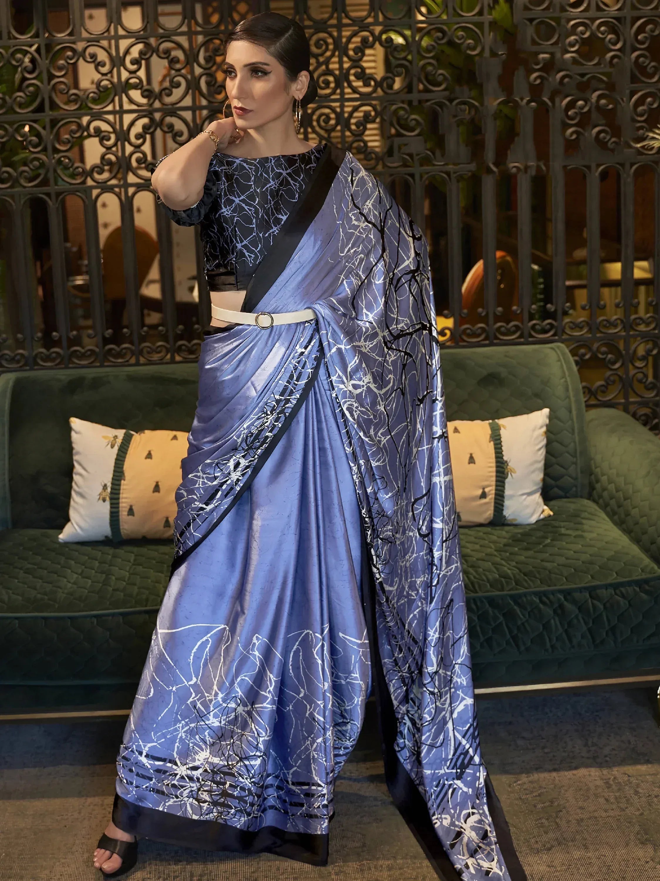 Woman in blue printed saree with black blouse and white belt, stylish ethnic wear for occasions