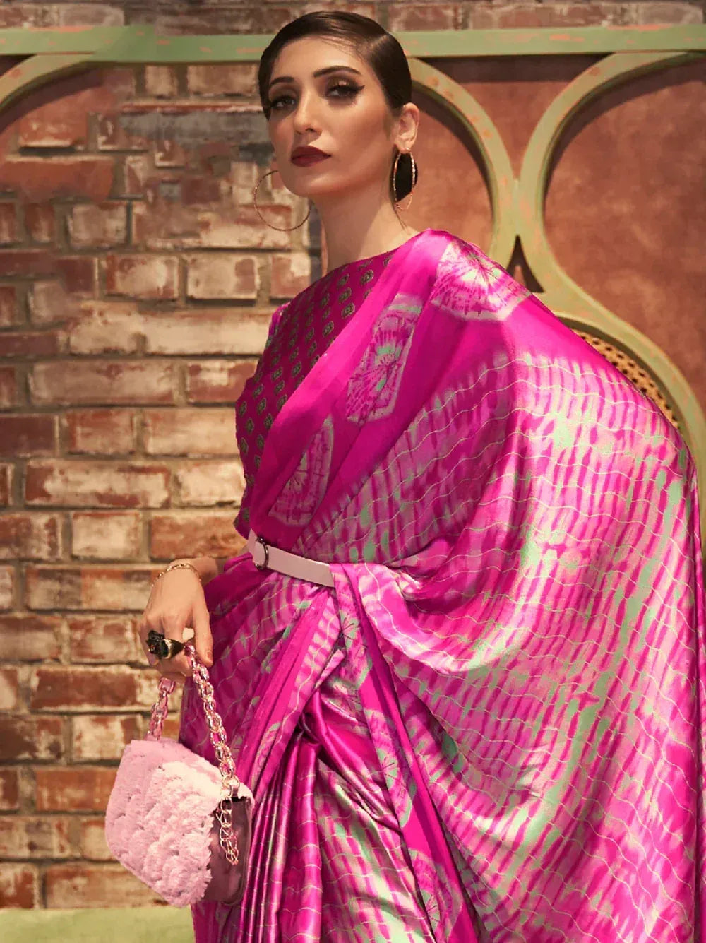 Vibrant pink and green printed saree with belt, styled for ethnic wear occasions