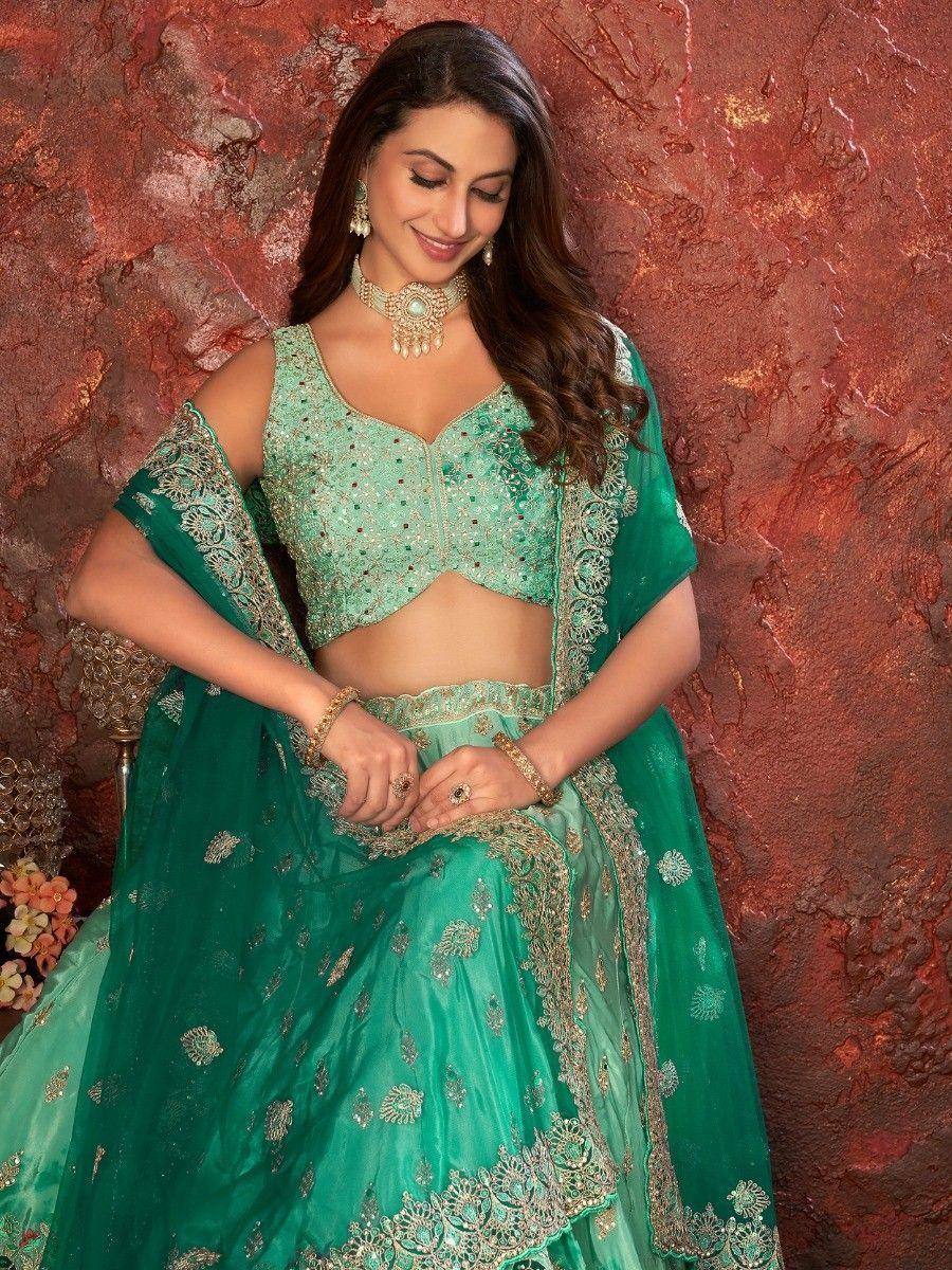 Emerald green designer lehenga choli with gold embroidery, perfect for Indian weddings and festive occasions.