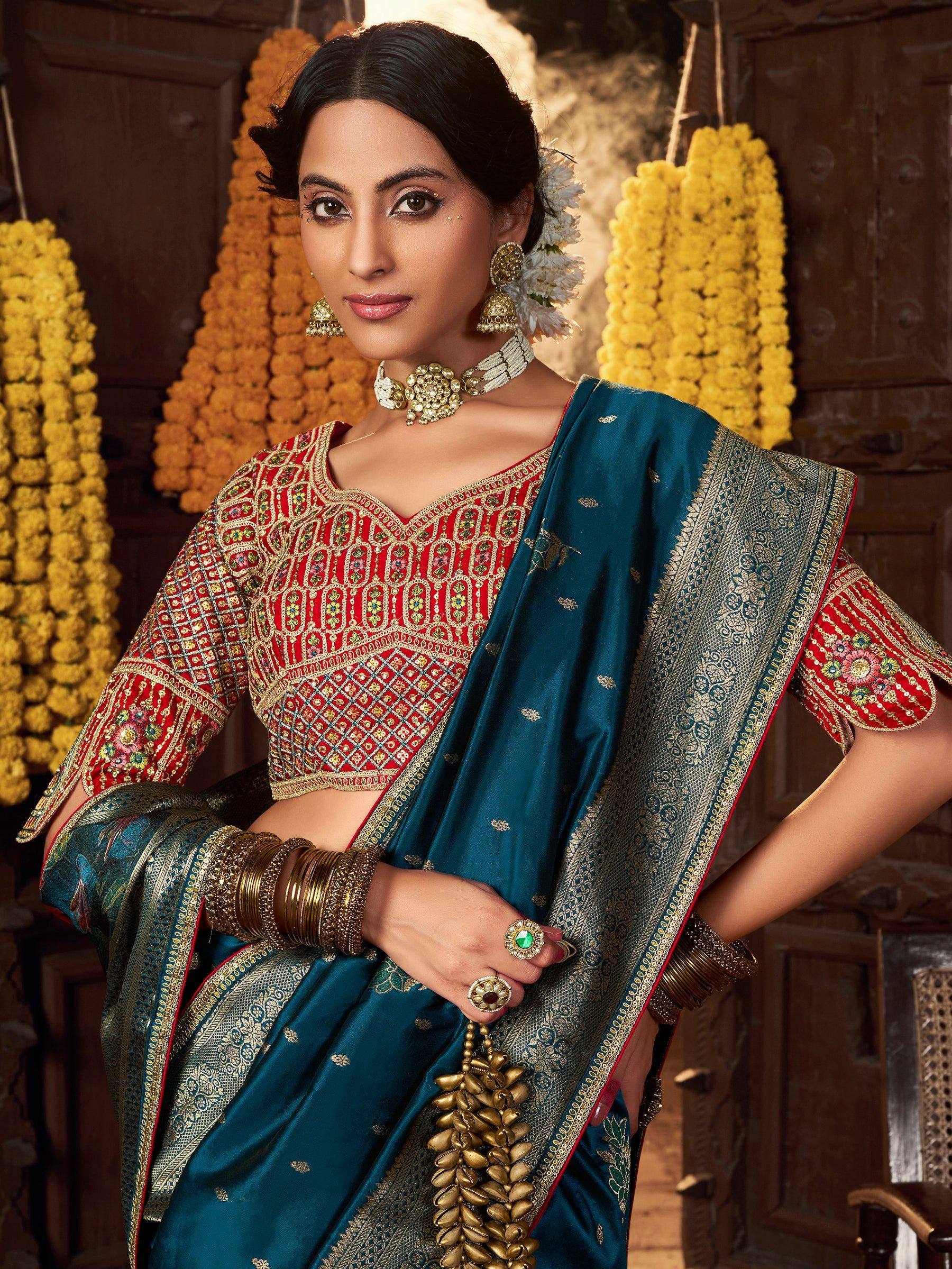 Woman in red embroidered blouse and teal saree with gold border, traditional Indian ethnic wear