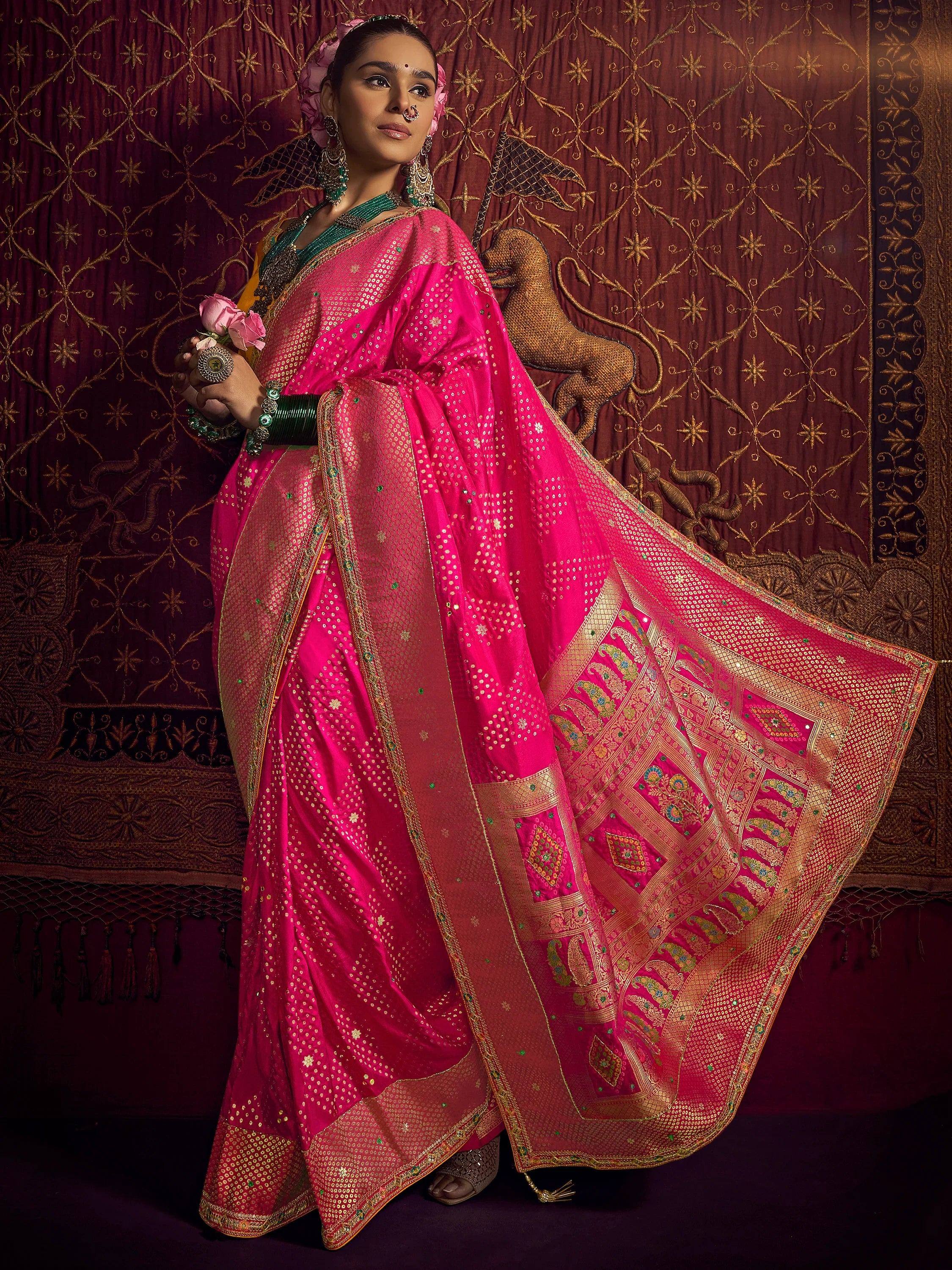 Vibrant pink designer saree with gold embroidery and mirror work, paired with green blouse, perfect for Indian ethnic occasions.
