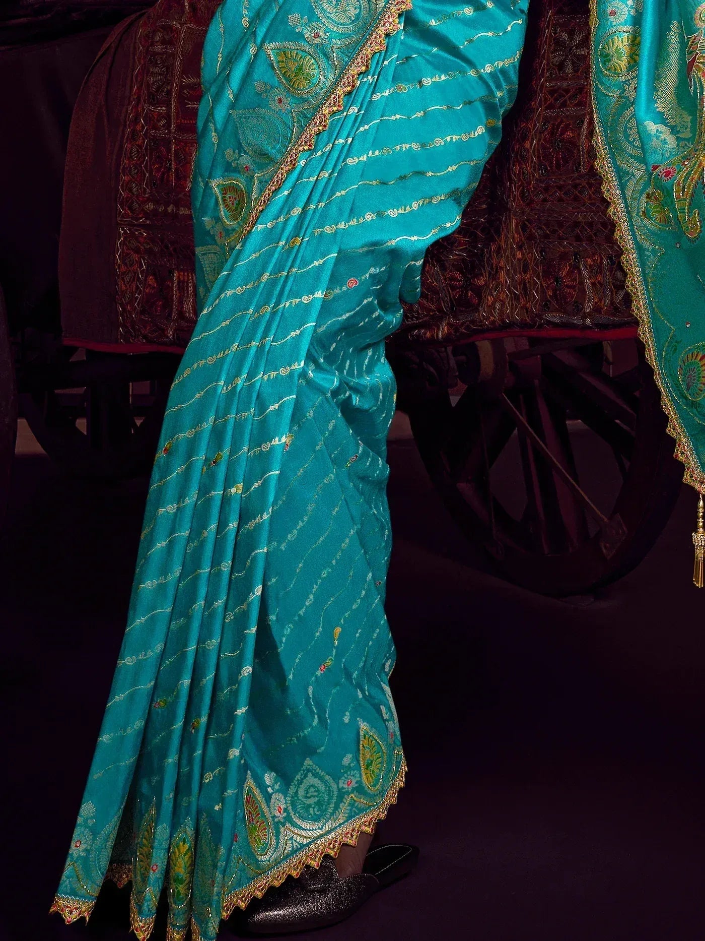 Teal Indian saree with gold paisley embroidery and scalloped border, styled with black flats
