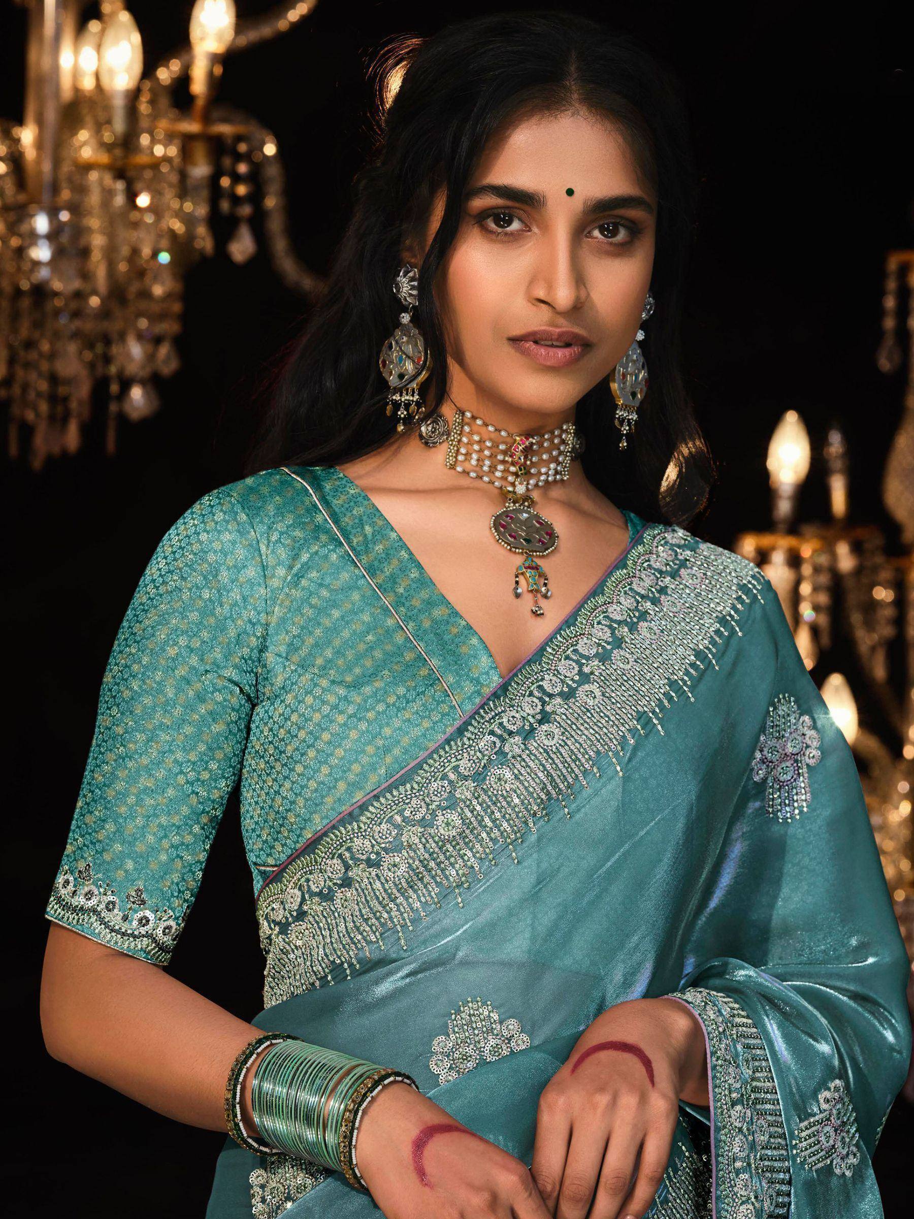 Teal designer saree with intricate embroidery and traditional jewelry for Indian ethnic wear