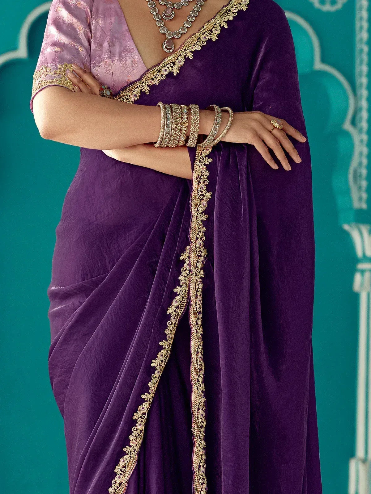 Purple velvet saree with gold embroidery, paired with pink blouse and traditional jewelry for ethnic wear