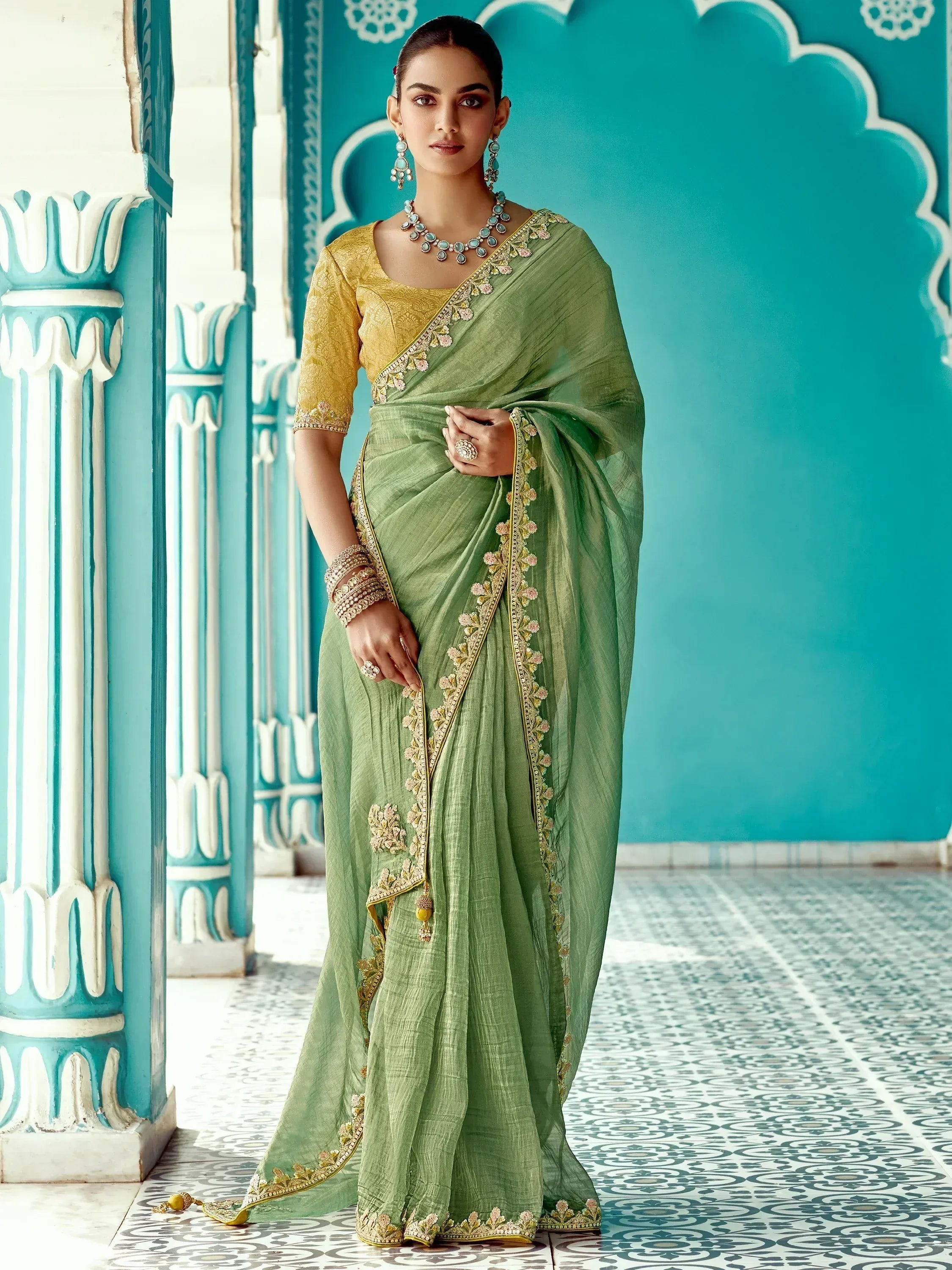 Elegant green saree with gold embroidery and yellow blouse, styled with traditional jewelry for Indian ethnic wear.