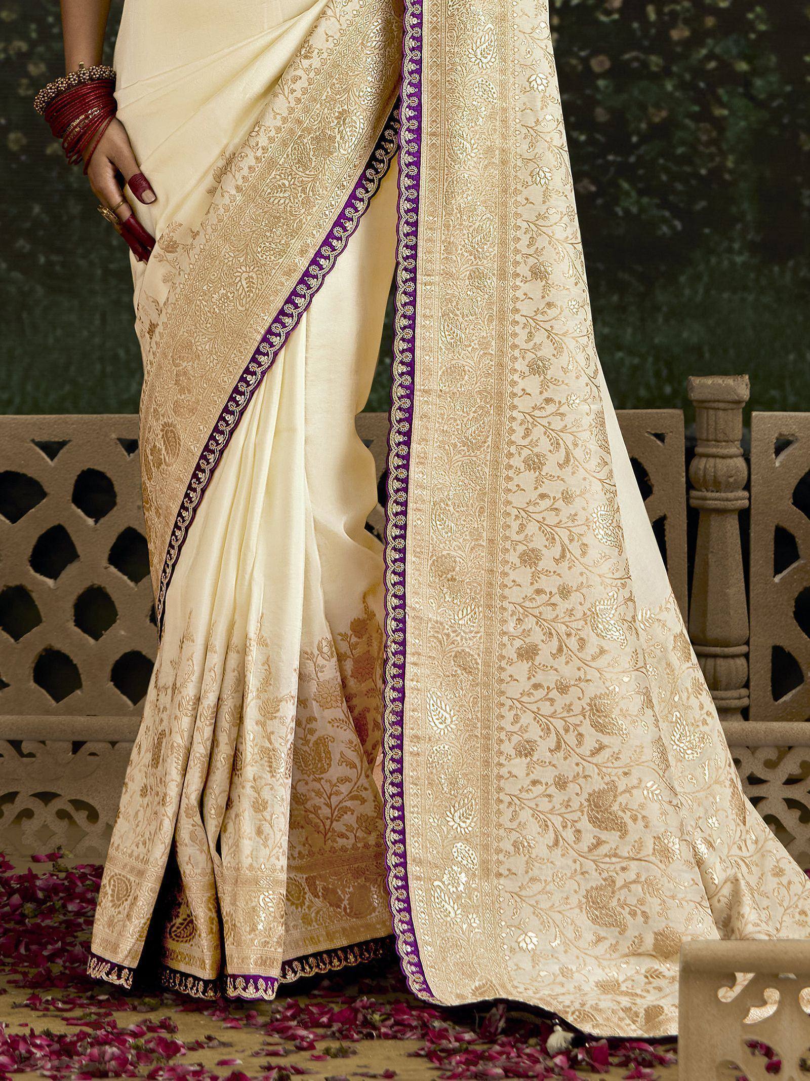 Cream designer saree with gold floral embroidery and purple border, perfect for Indian ethnic wear occasions.