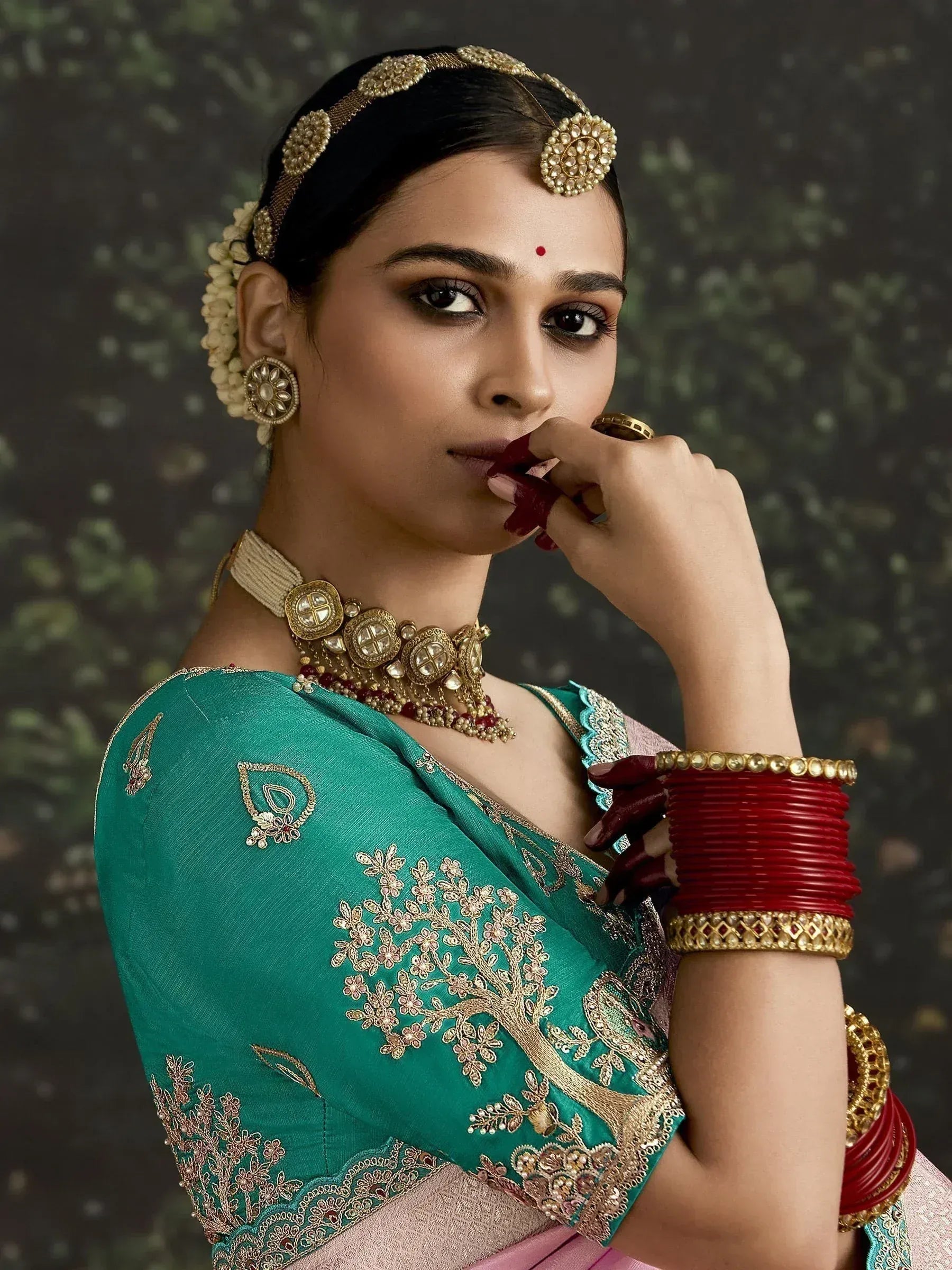 Woman in teal embroidered saree with gold jewelry and red bangles, traditional Indian ethnic wear