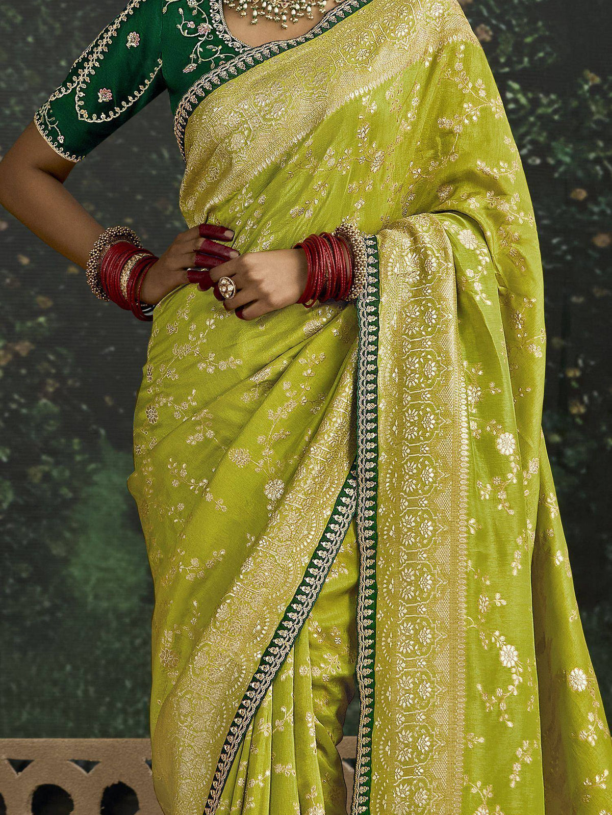 Lime green designer saree with gold floral embroidery, paired with emerald green blouse and traditional jewelry