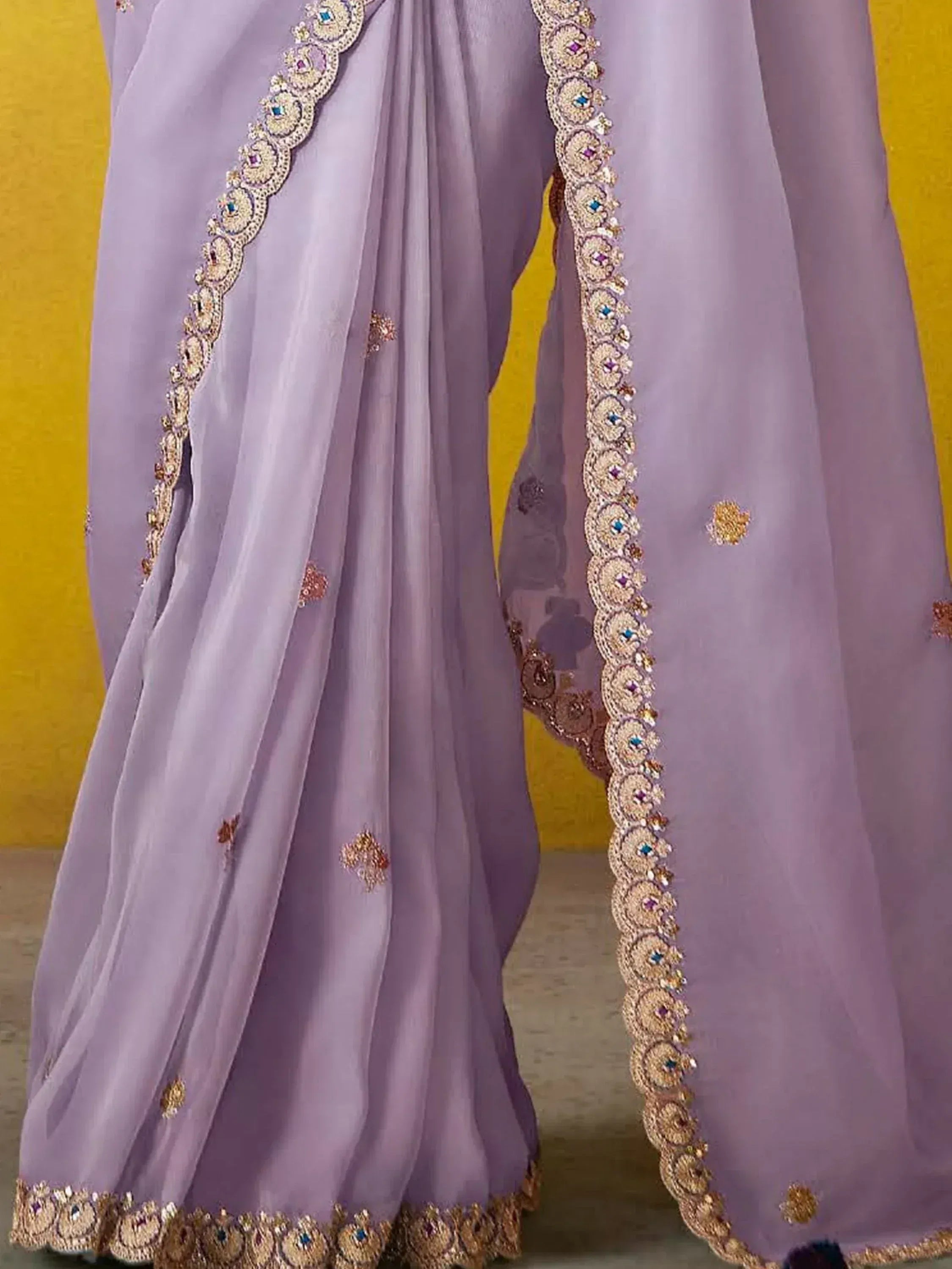 Lavender ethnic gown with gold embroidery and stone work, perfect for Indian weddings and festive occasions.