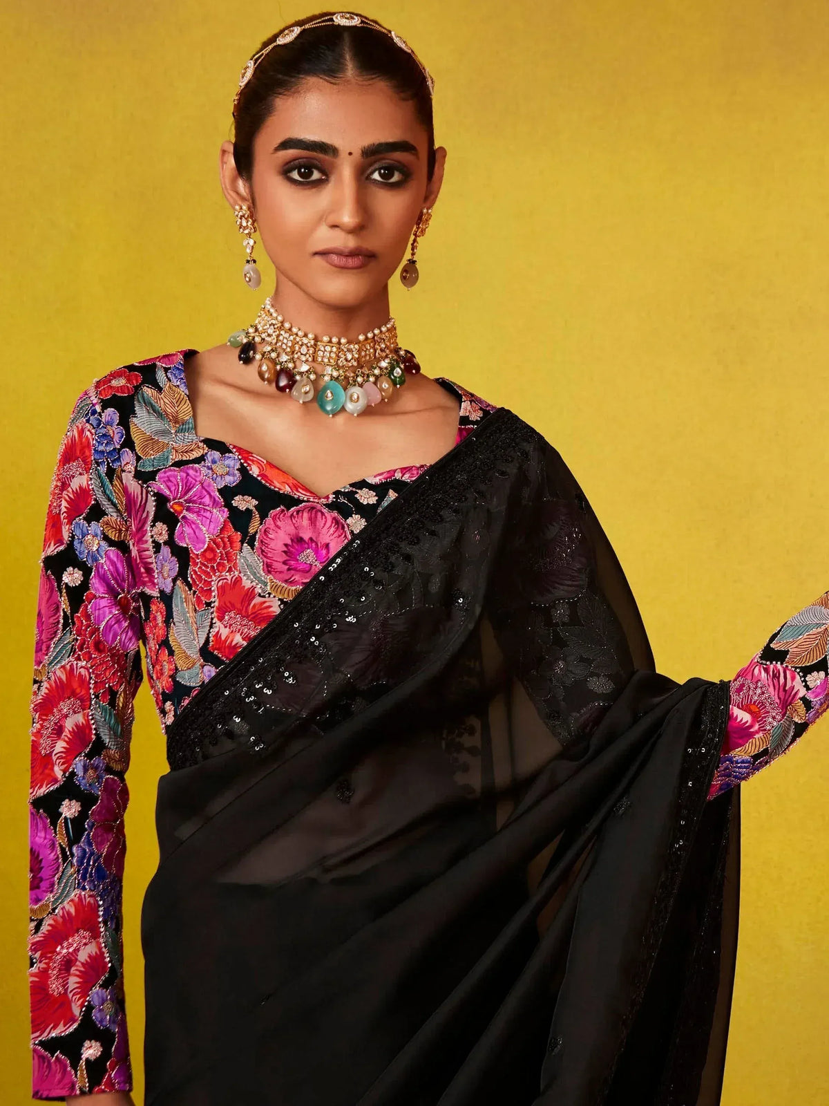Black saree with vibrant floral blouse, perfect for Indian ethnic wear events and celebrations.