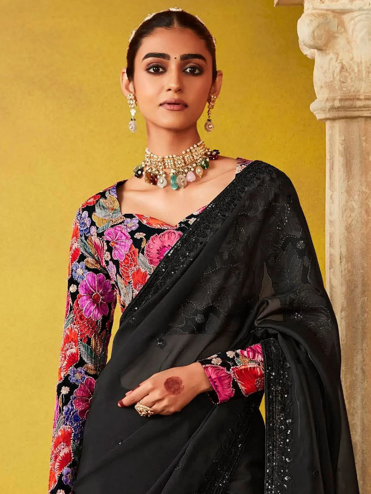 Black floral embroidered saree with sequin border, styled with traditional Indian jewelry for ethnic wear