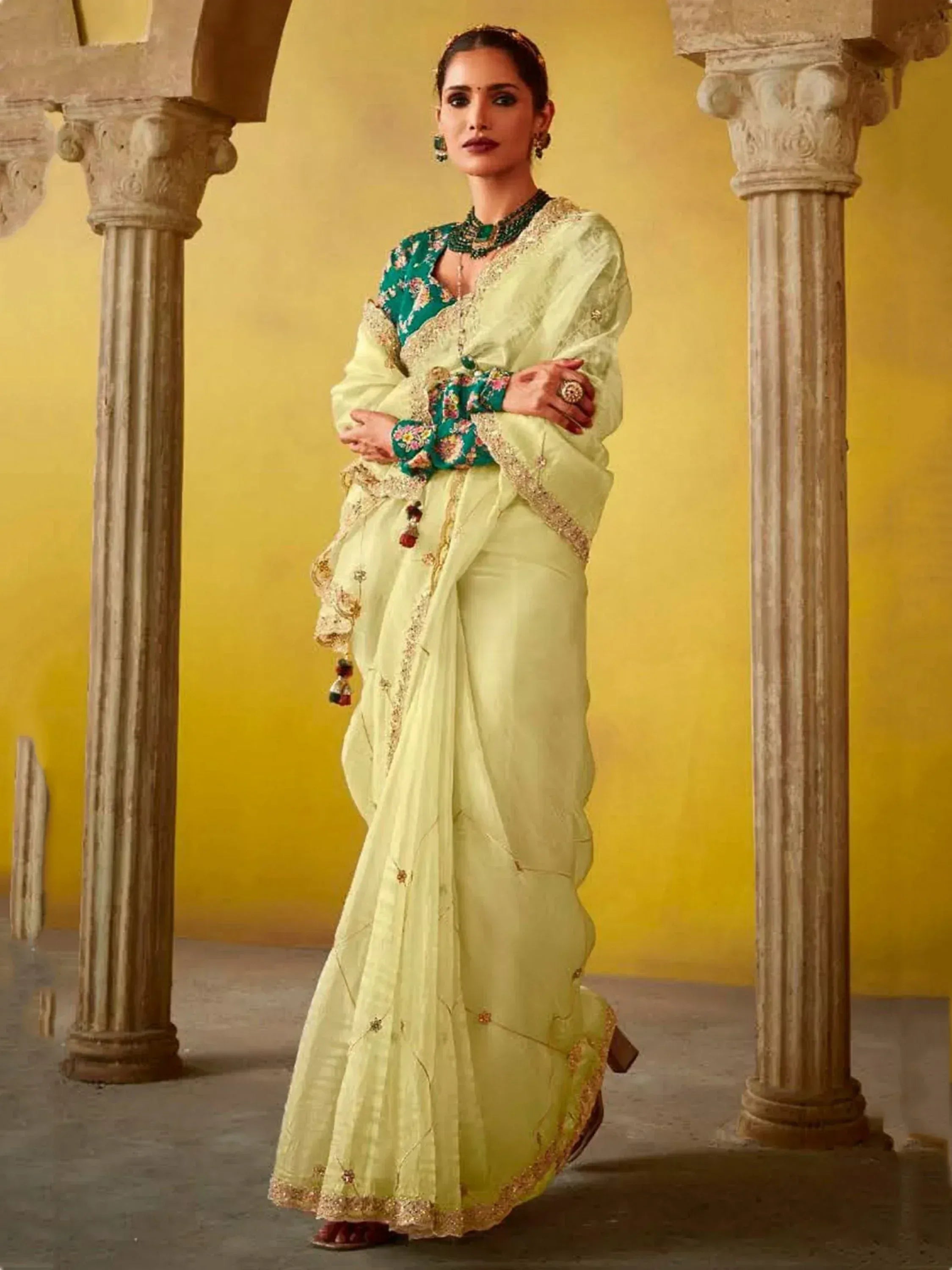 Elegant light green saree with floral embroidery and gold detailing, paired with a teal blouse, perfect for Indian ethnic occasions.