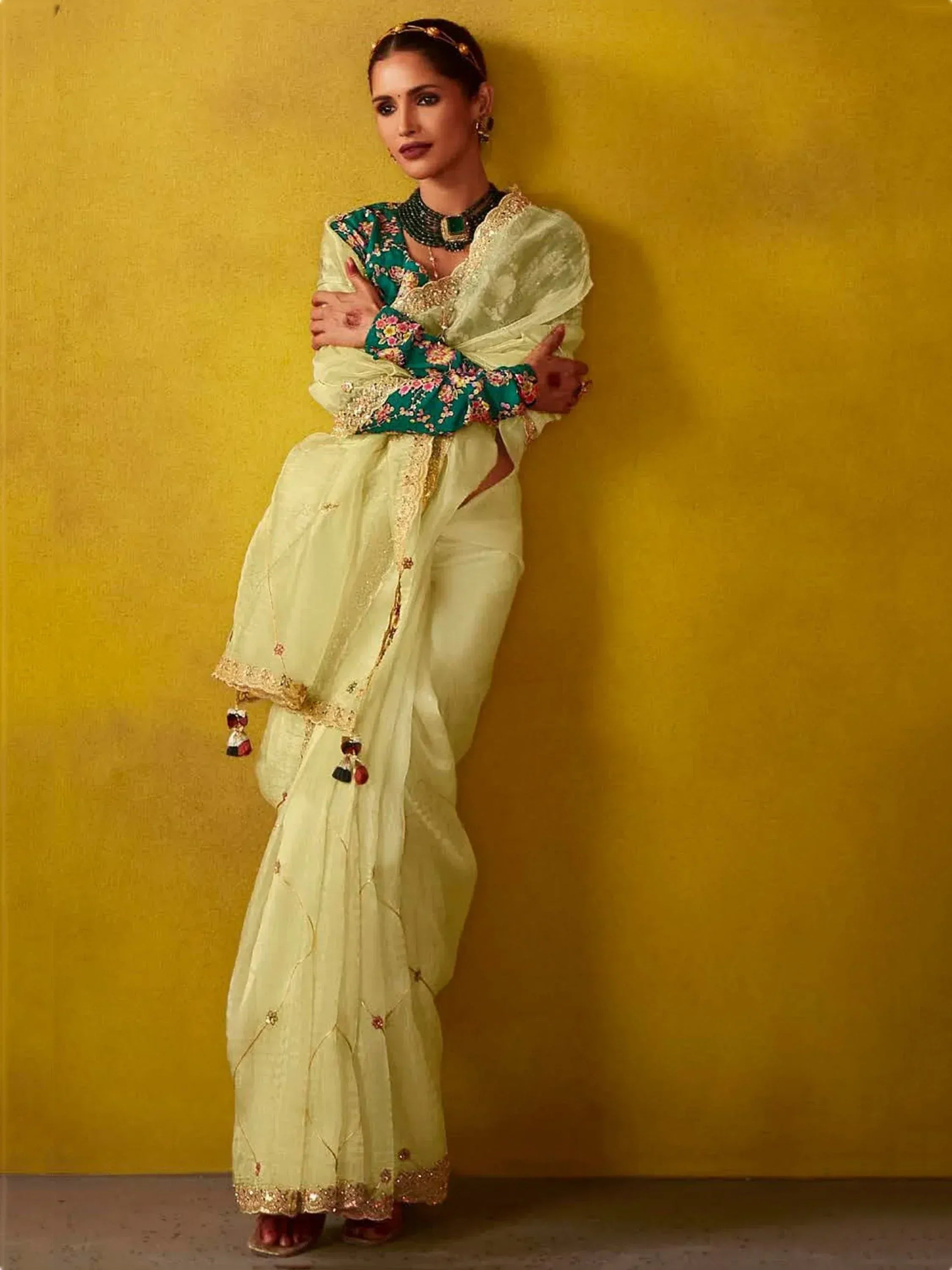 Woman in light green ethnic sharara set with floral blouse and gold embroidery, perfect for Indian occasions