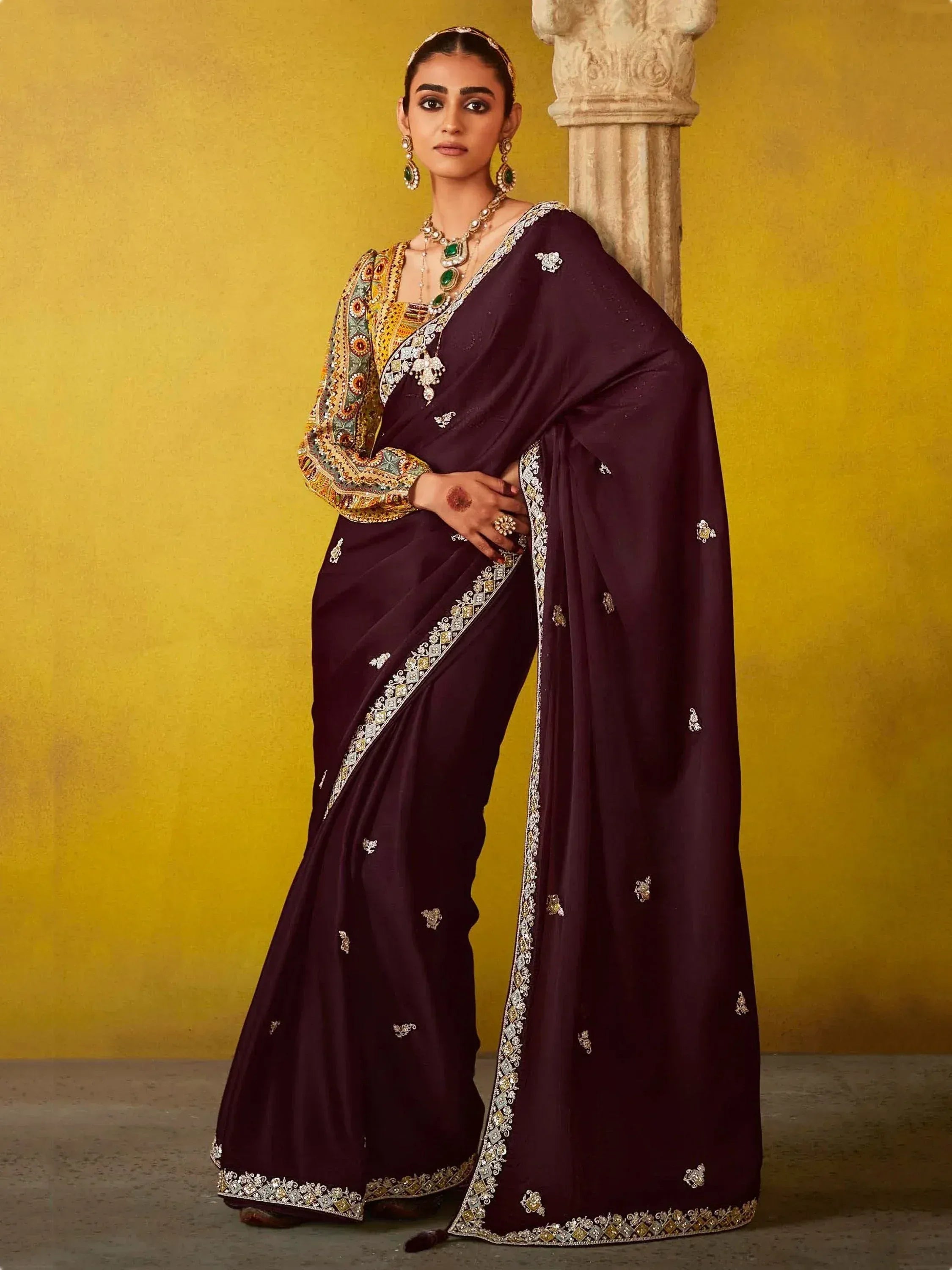 Elegant purple saree with intricate gold embroidery and embellished border, paired with designer blouse and traditional jewelry
