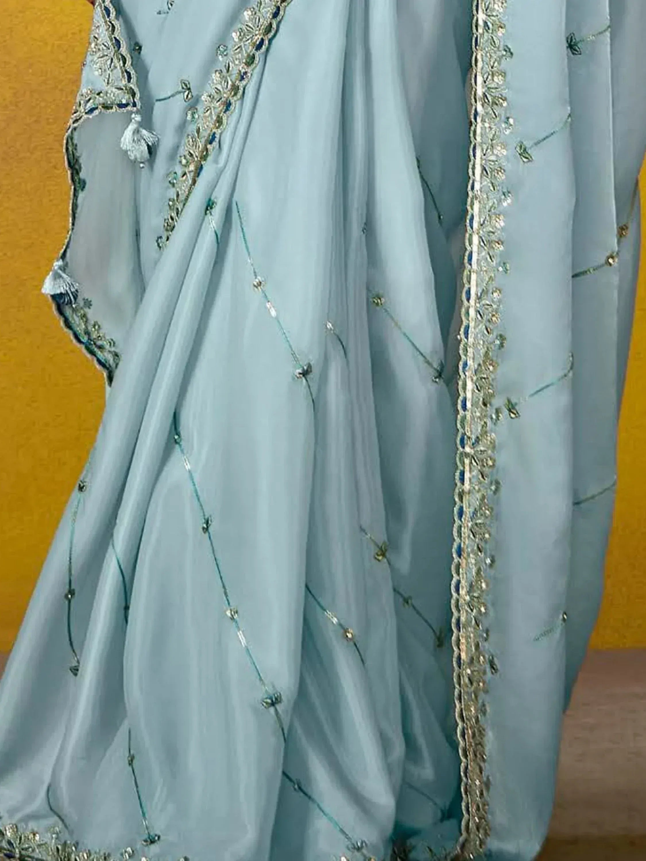 Light blue ethnic gown with intricate gold and silver embroidery, perfect for Indian celebrations.