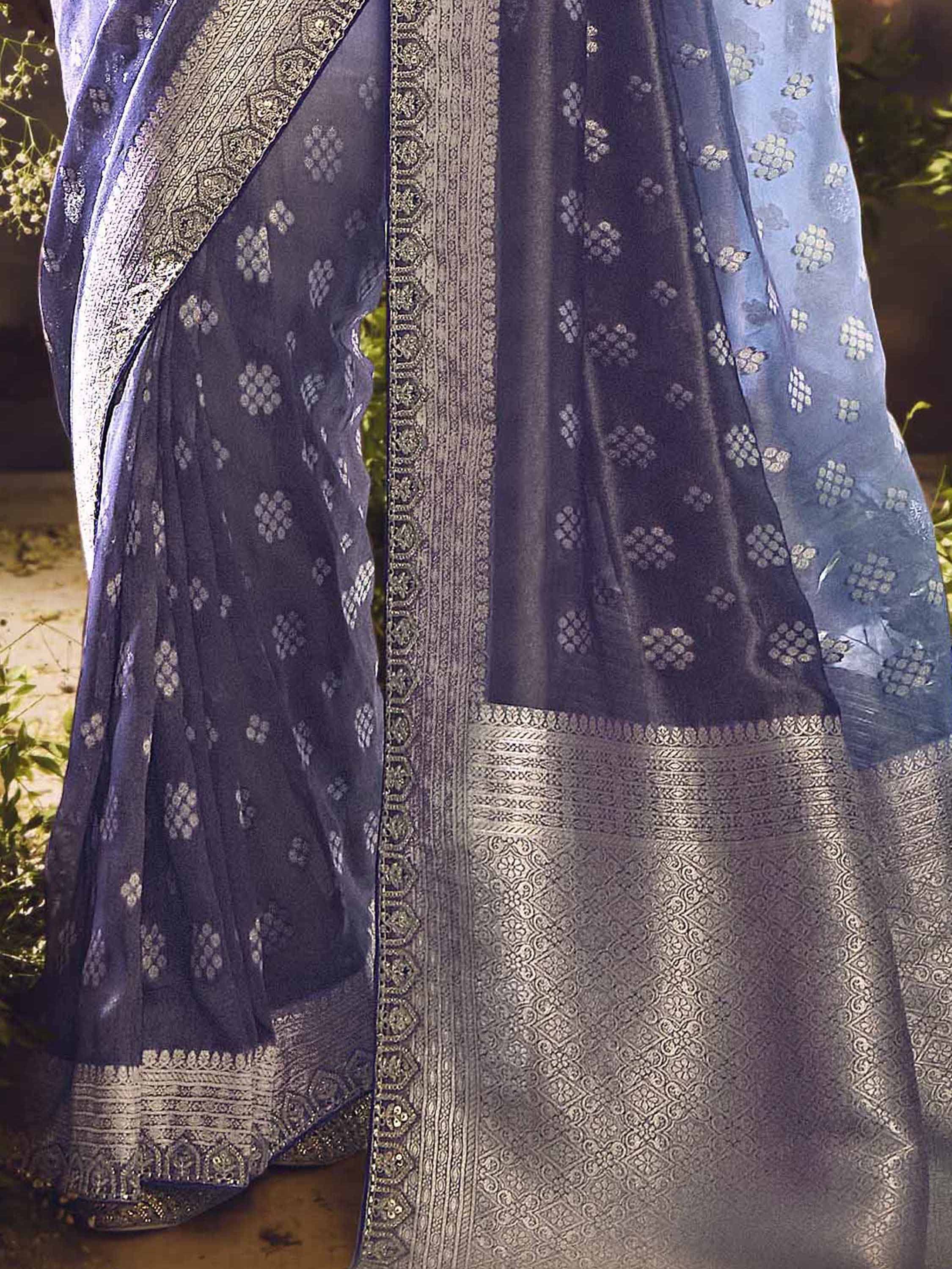Elegant navy blue saree with silver floral motifs and intricate border, perfect for Indian ethnic wear.