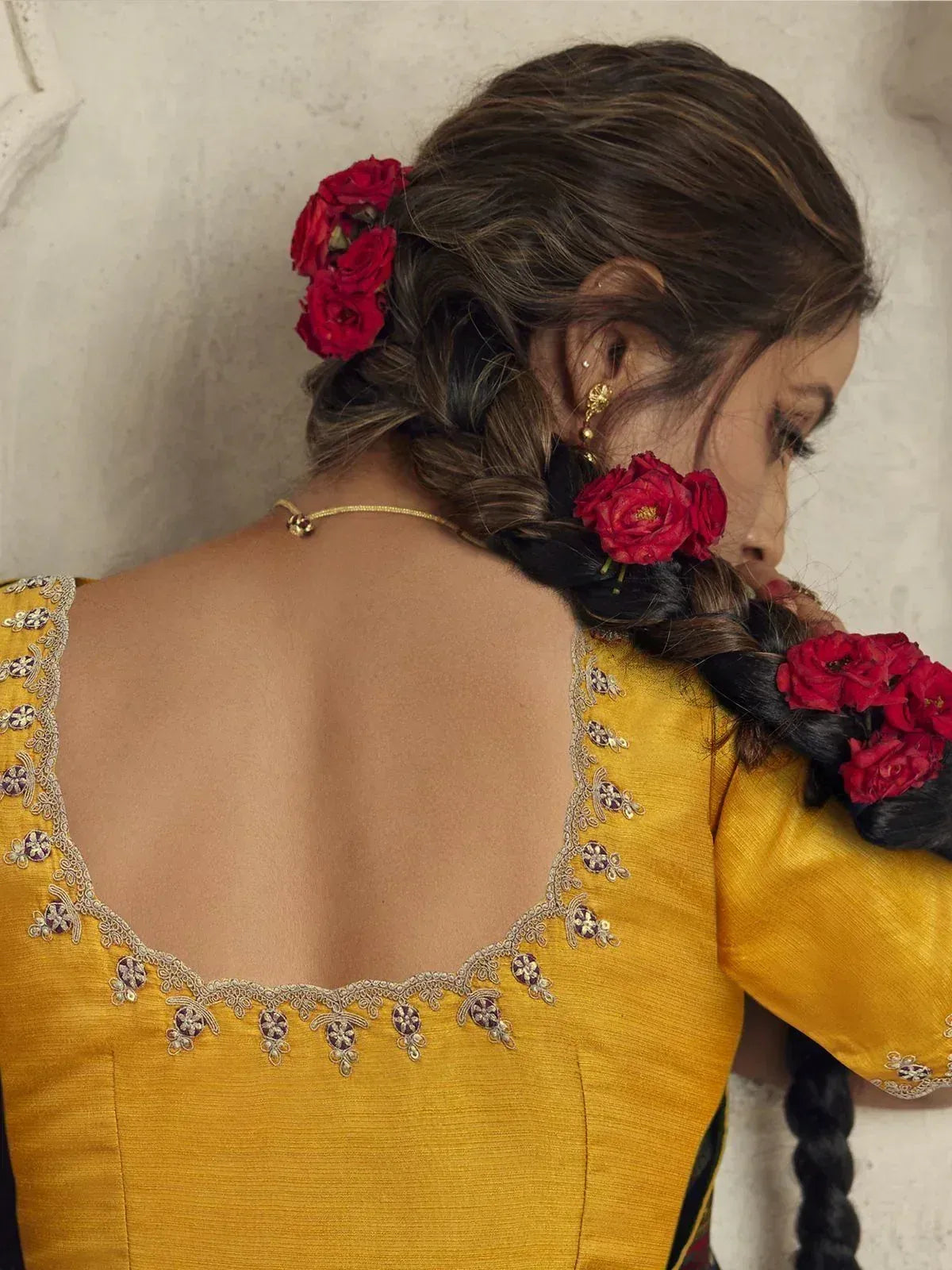 Yellow embroidered ethnic blouse with floral hair accessories, perfect for Indian festive wear