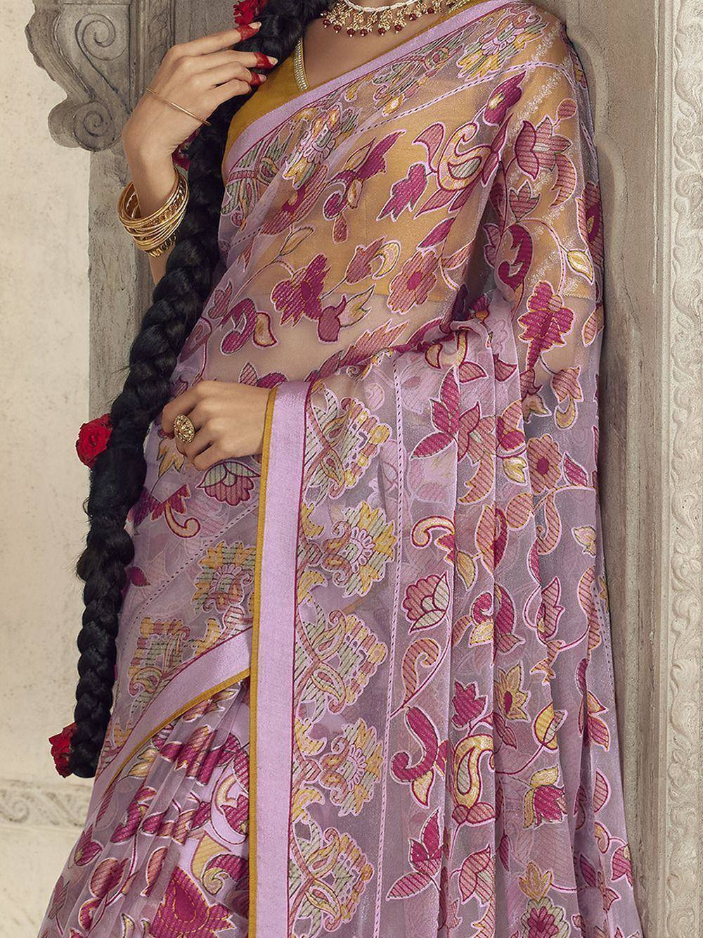 Elegant purple floral saree with gold border, styled with traditional jewelry and braided hair adorned with roses