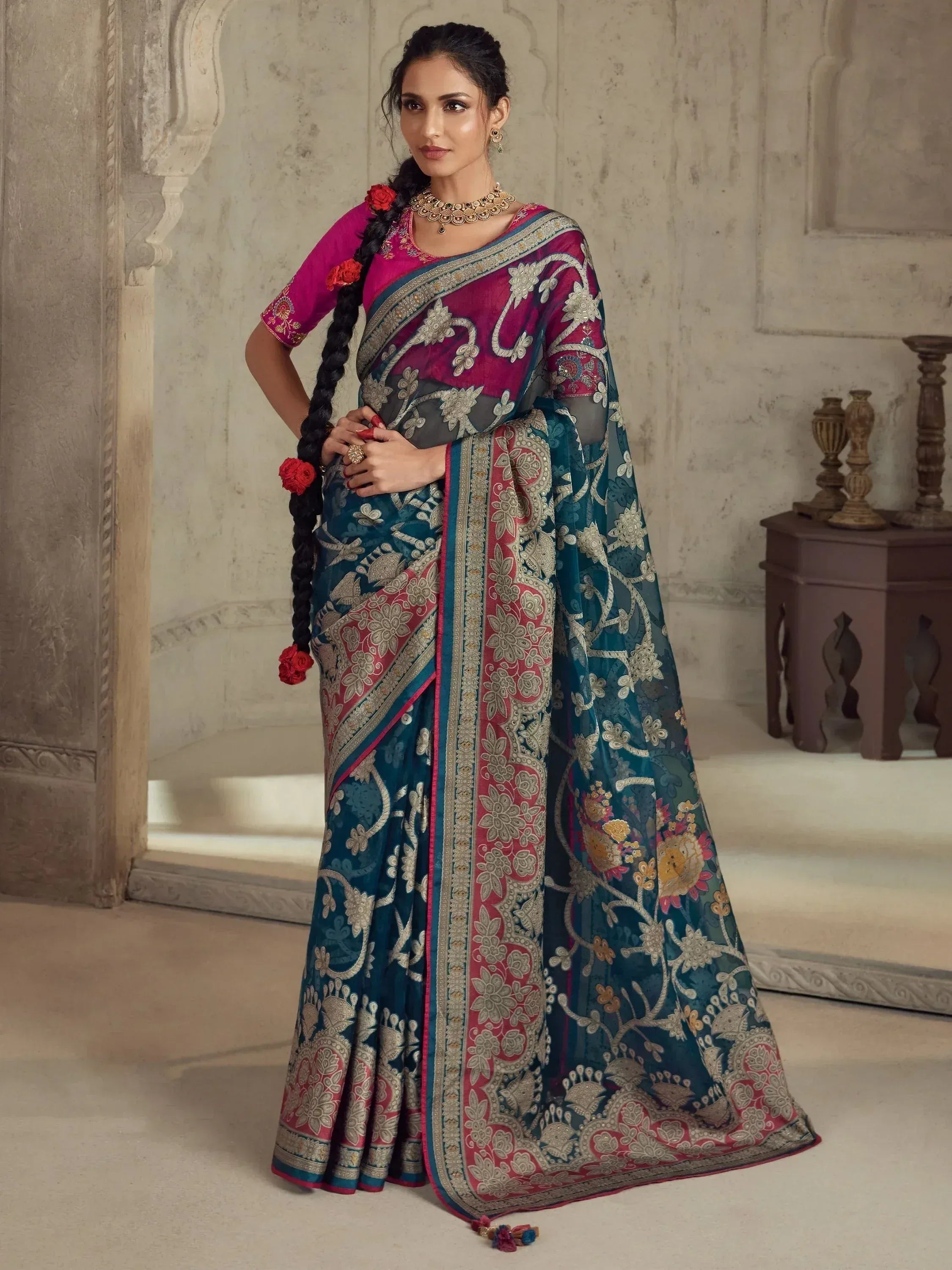 Elegant teal and magenta embroidered saree with floral motifs, perfect for Indian ethnic wear occasions.
