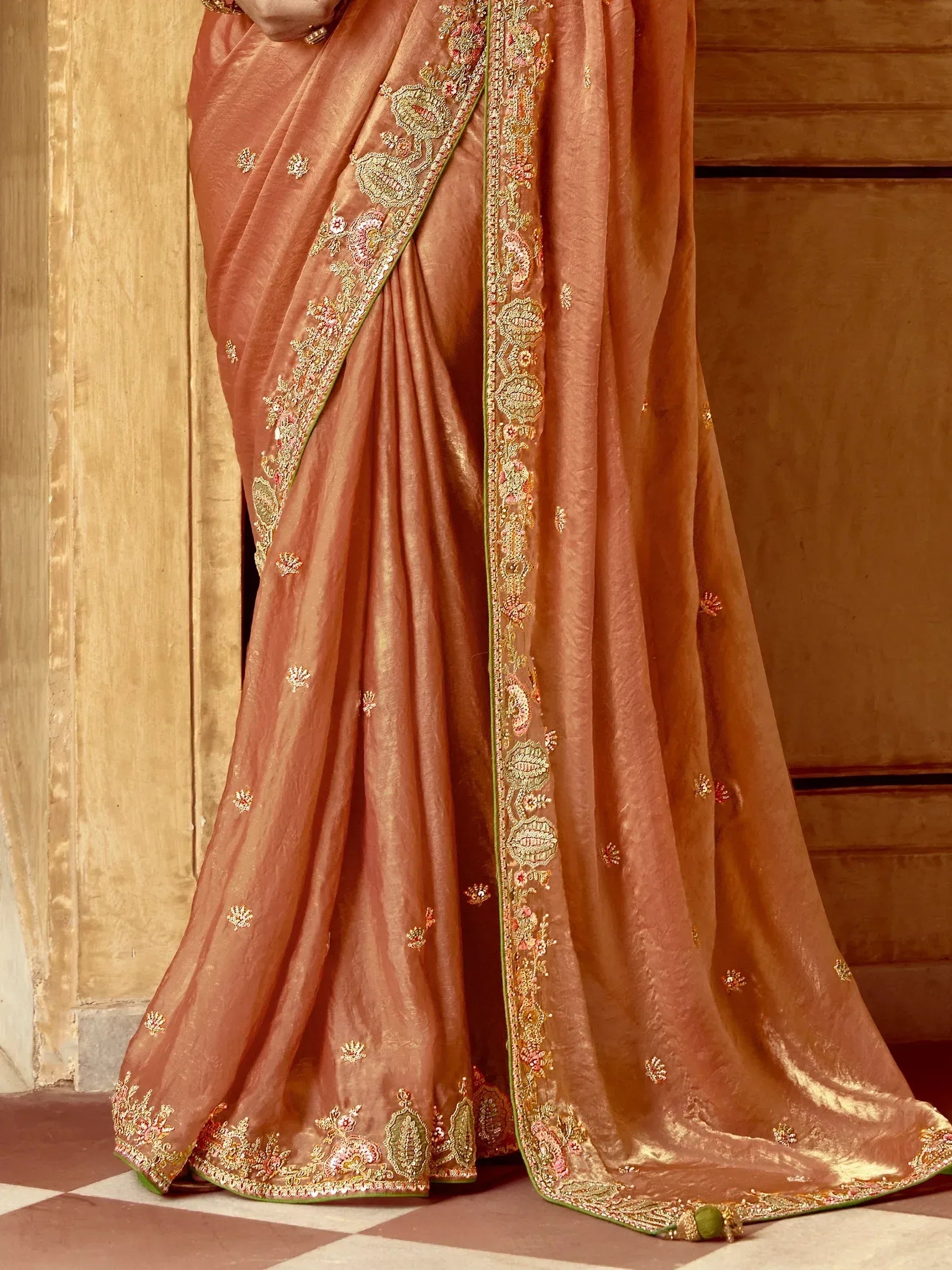 Elegant peach saree with intricate gold and floral embroidery, perfect for Indian ethnic wear.