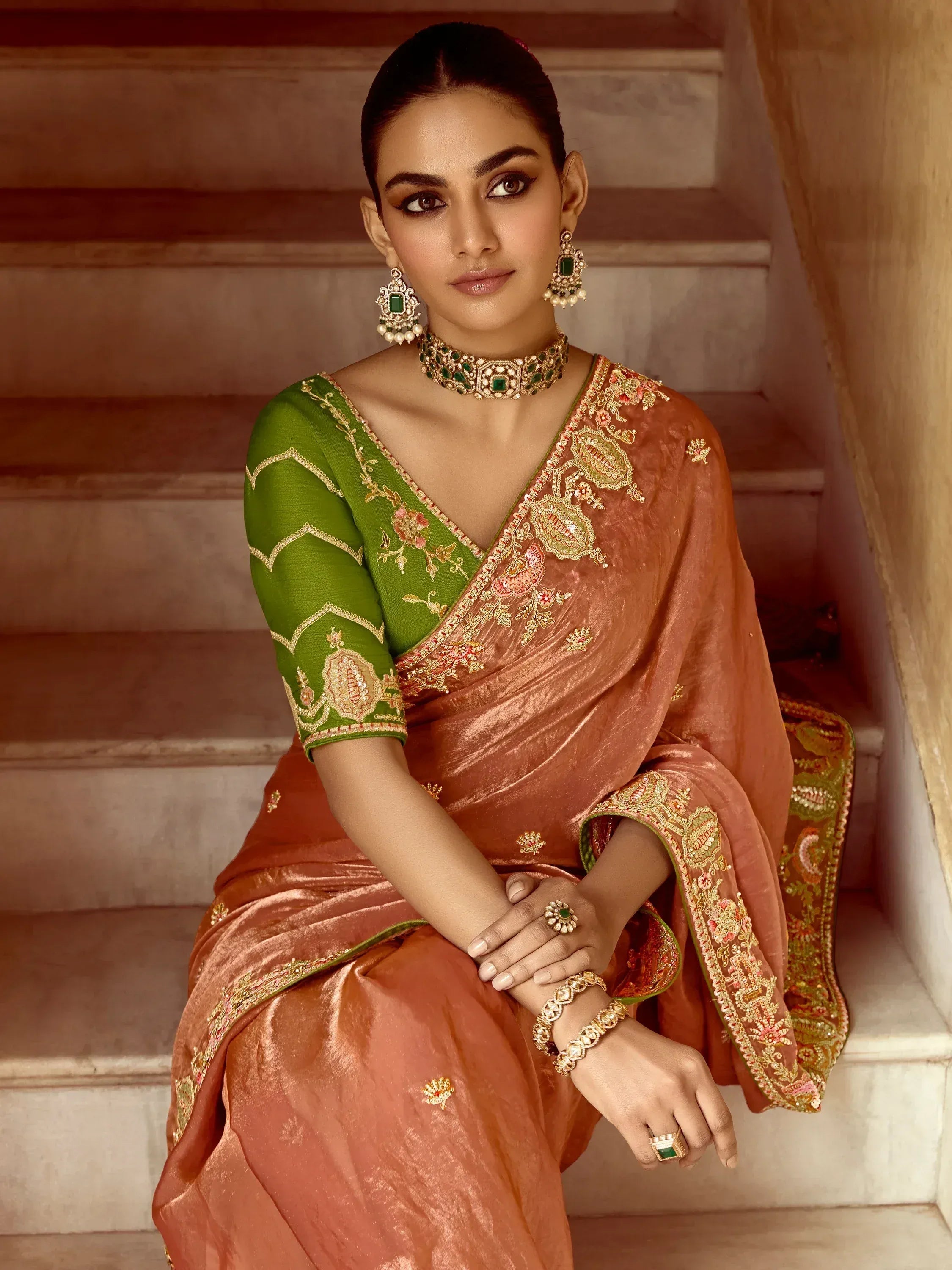 Elegant woman in embroidered orange saree with green blouse, traditional Indian ethnic wear