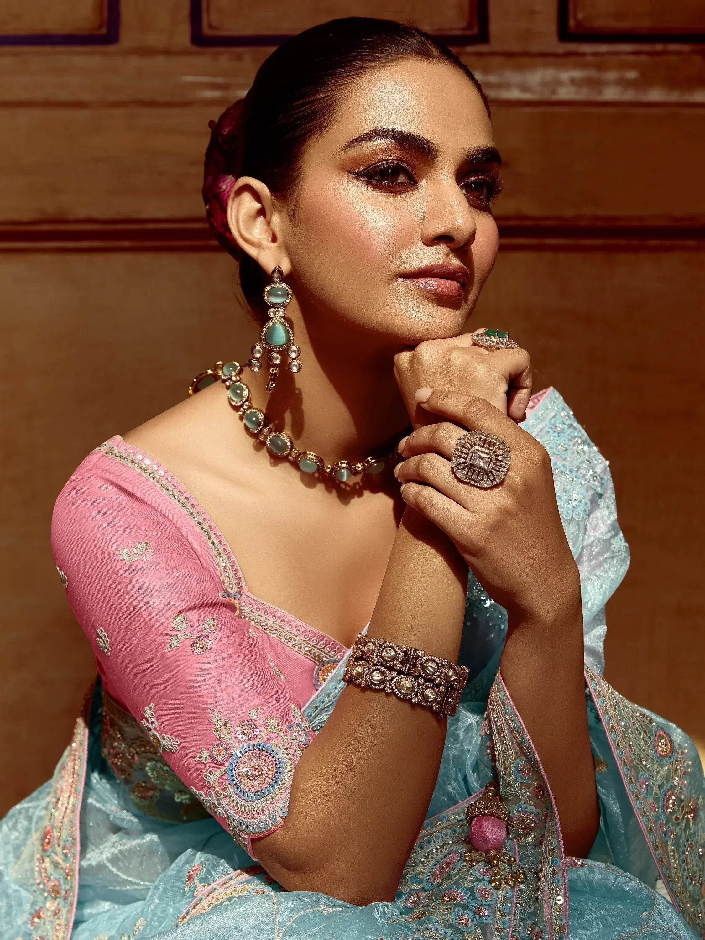 Elegant woman in pink and blue embroidered lehenga choli with traditional jewelry