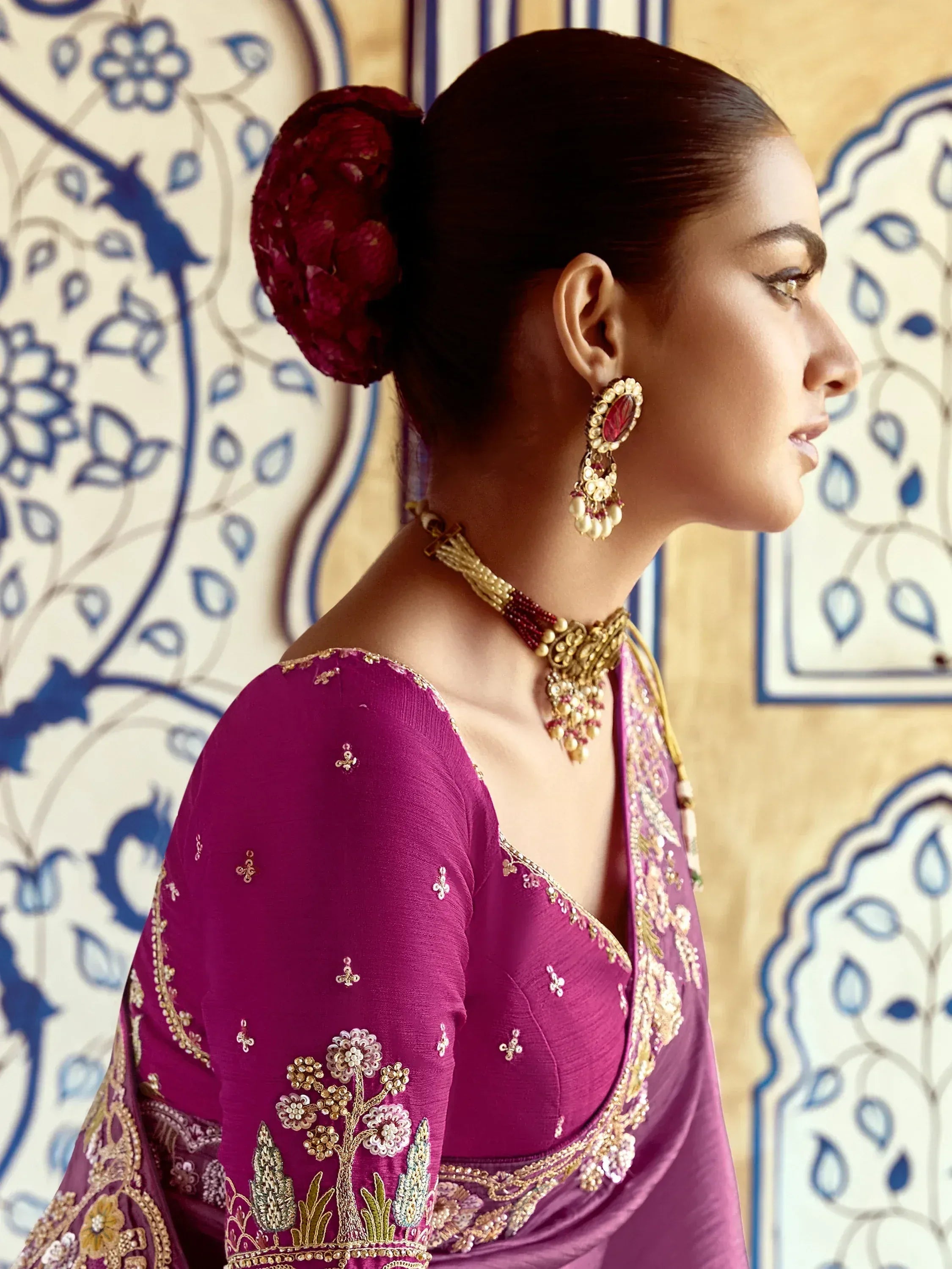 Elegant purple embroidered saree with gold detailing and traditional jewelry