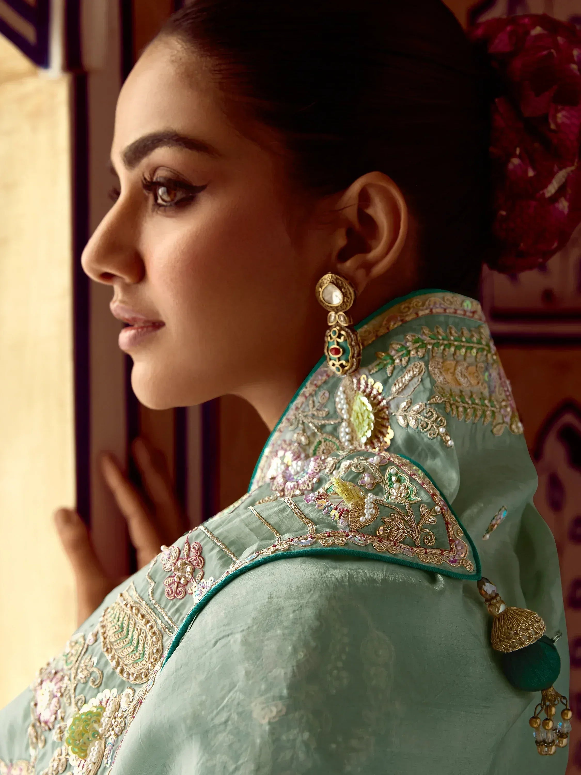 Elegant woman in designer ethnic wear with intricate embroidery and gold jewelry