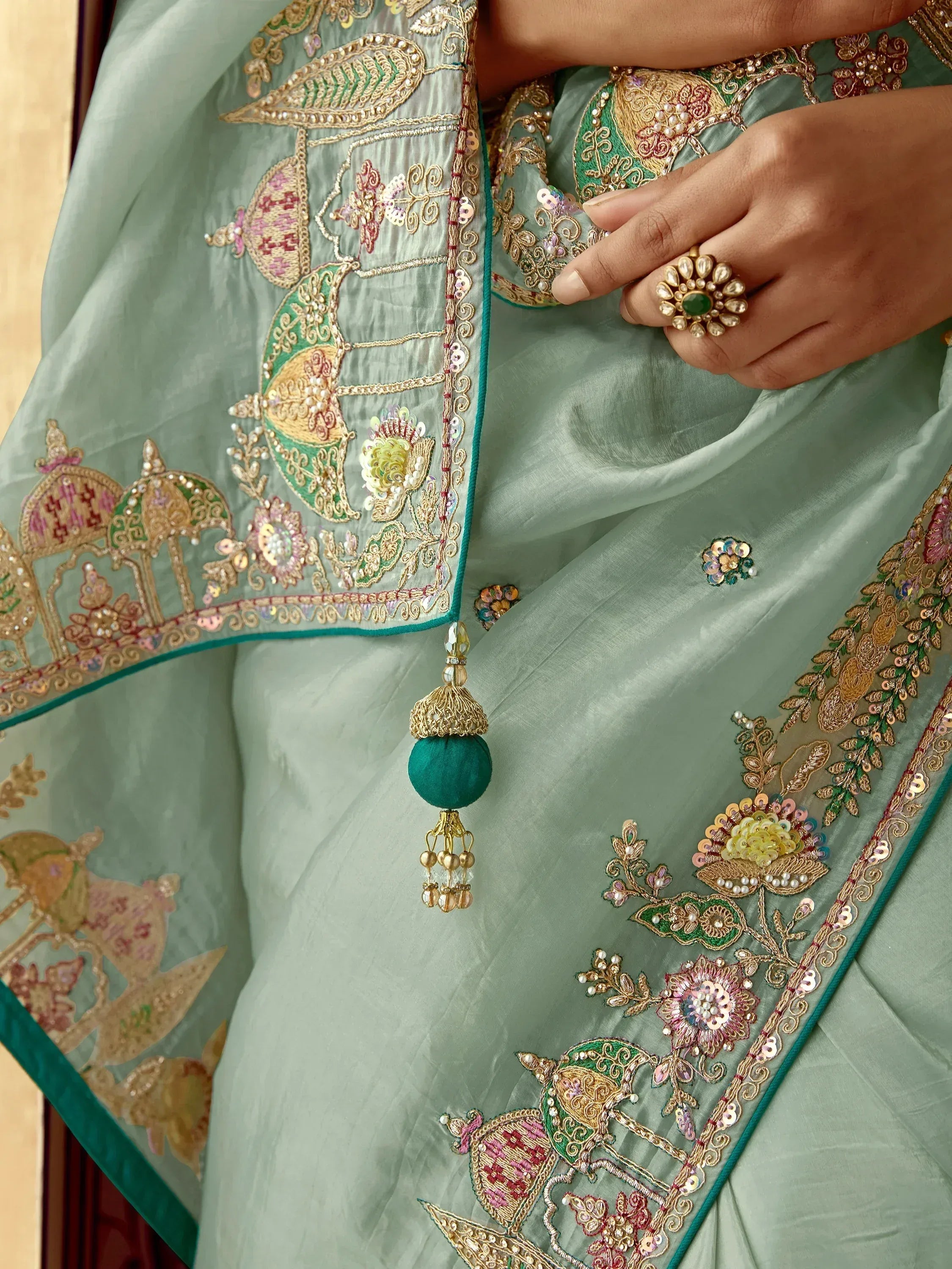 Elegant mint green saree with intricate floral embroidery and gold detailing, perfect for ethnic wear.