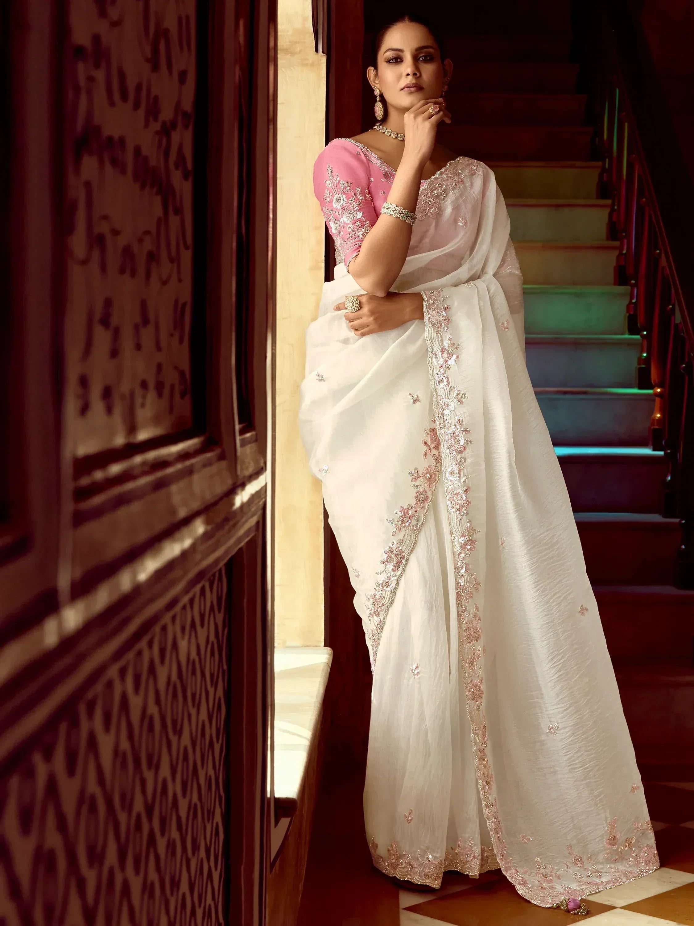 Elegant white saree with pink embroidery, paired with a designer blouse, perfect for Indian ethnic wear.