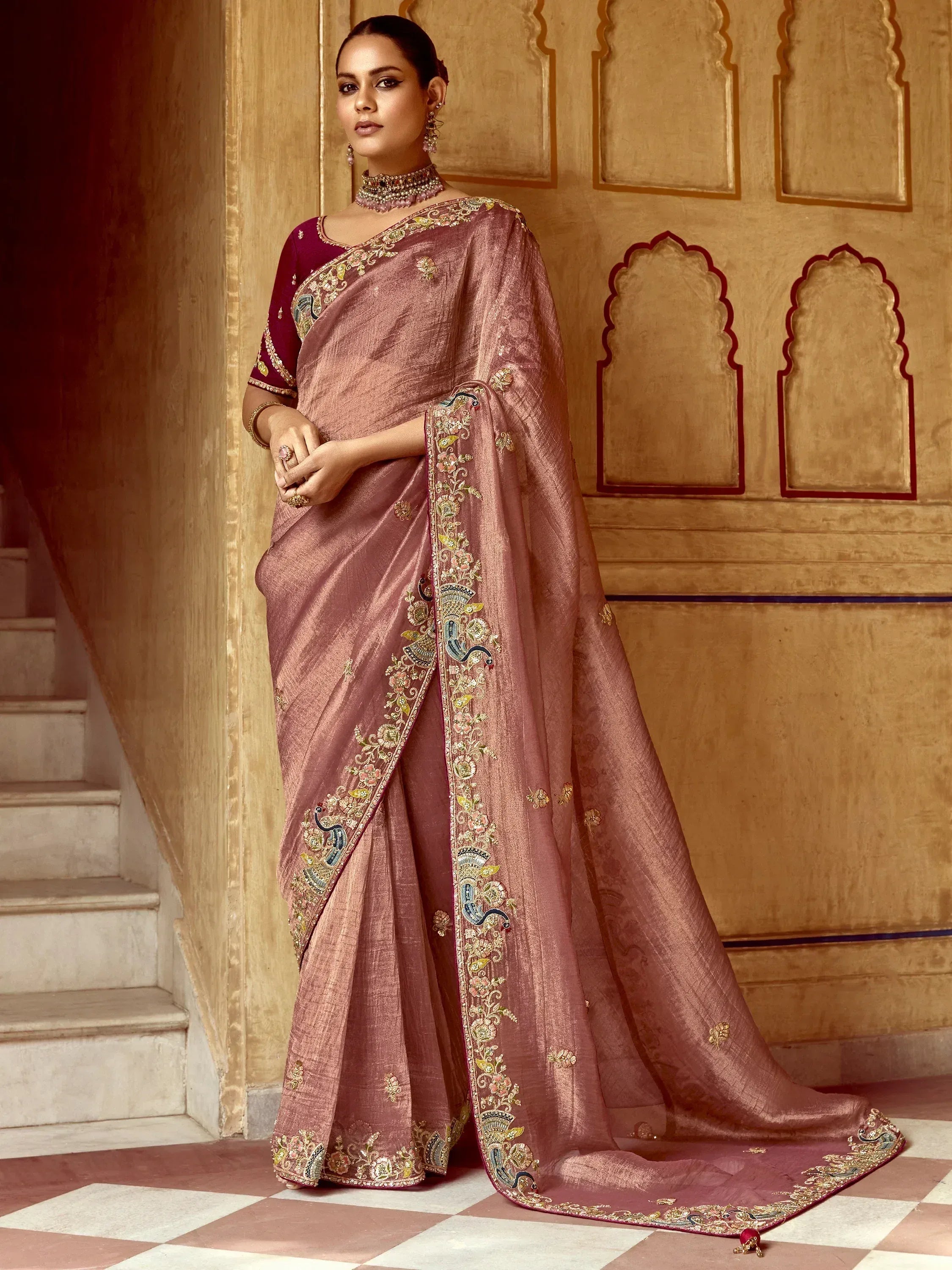 Elegant mauve saree with intricate gold embroidery and peacock motifs, paired with a matching blouse.