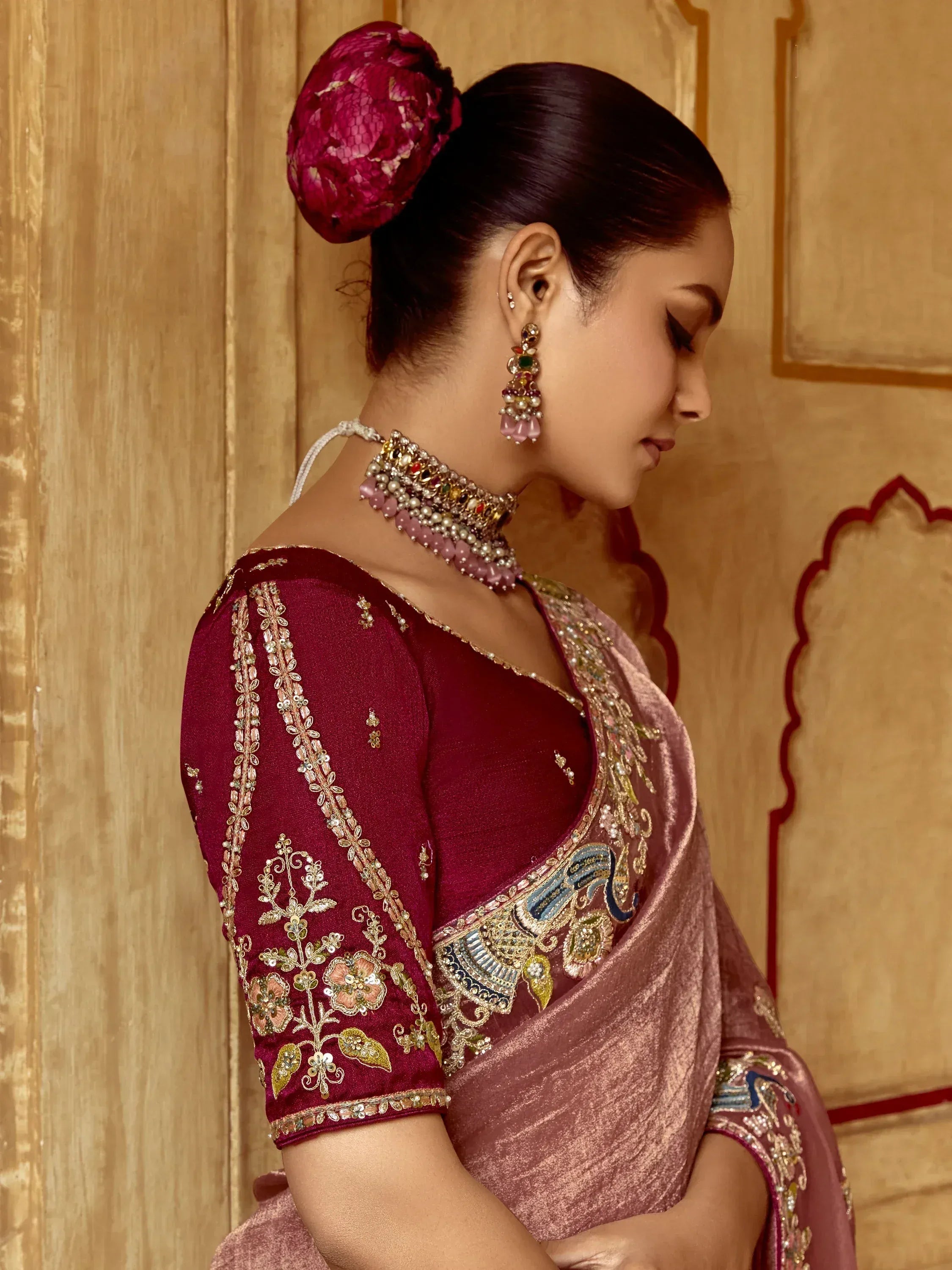 Elegant maroon and pink embroidered saree with intricate floral designs and traditional jewelry