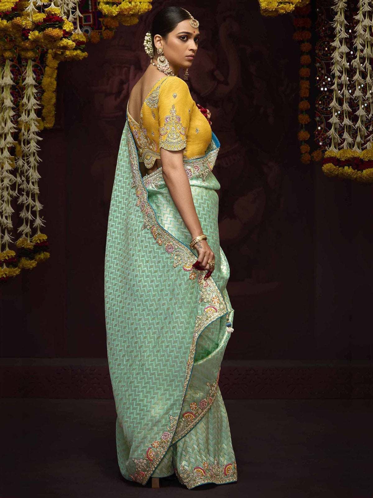Mint green embroidered saree with yellow blouse, floral garlands, traditional Indian ethnic wear