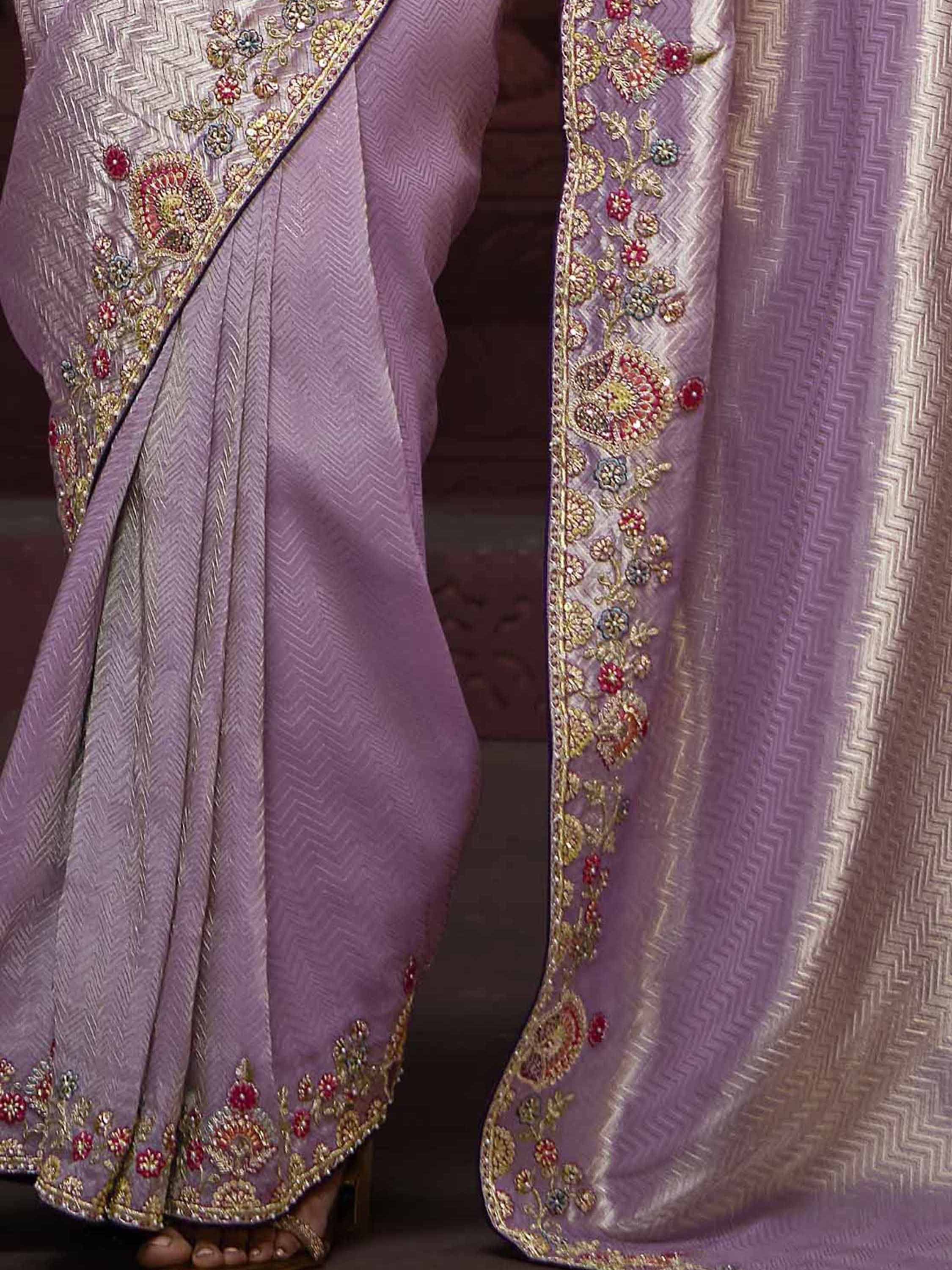 Lavender ethnic saree with gold floral embroidery and zigzag weave pattern, perfect for Indian occasions.