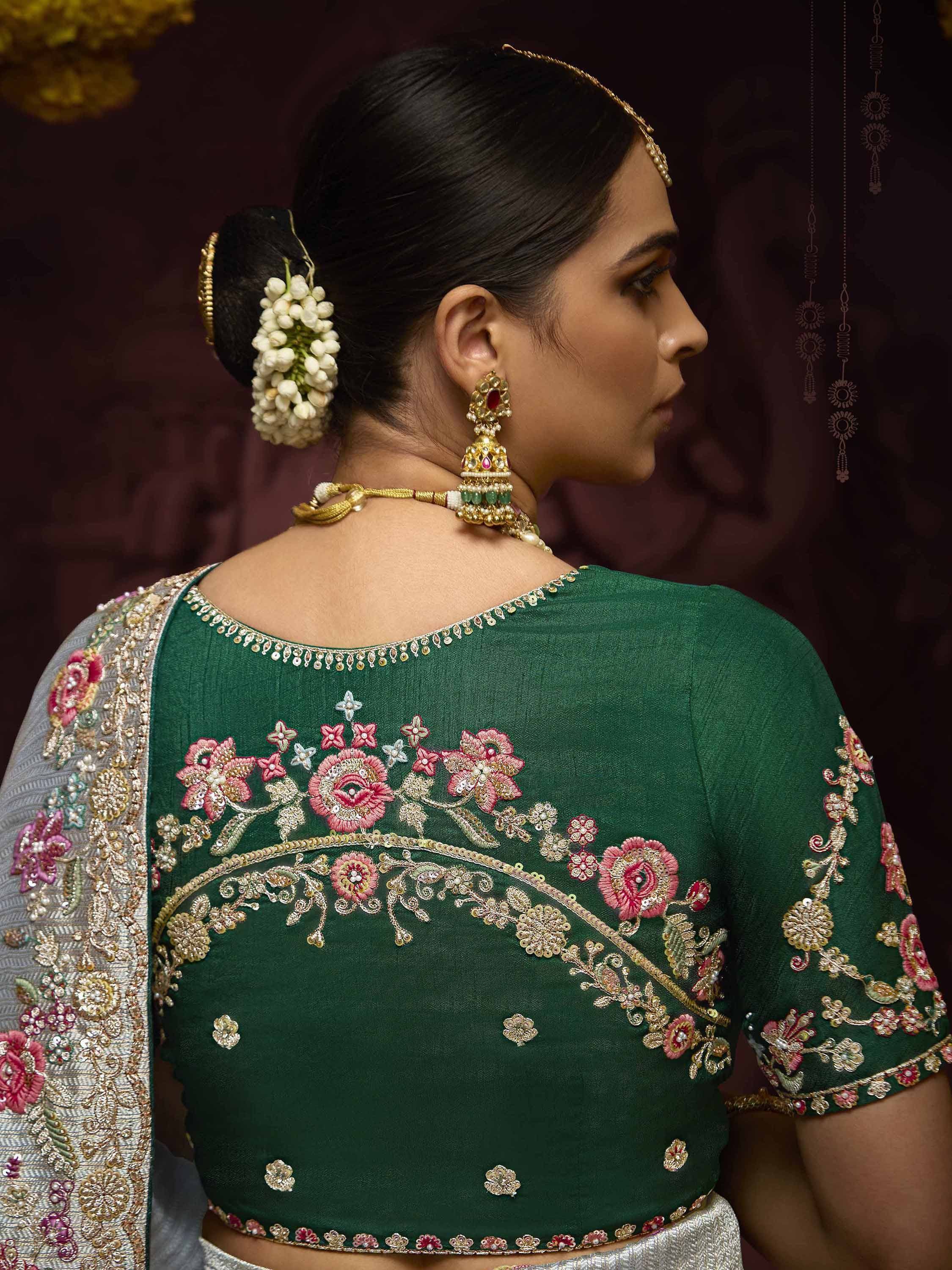Green embroidered lehenga choli with floral detailing, gold jewelry, and floral hair accessory for Indian ethnic wear