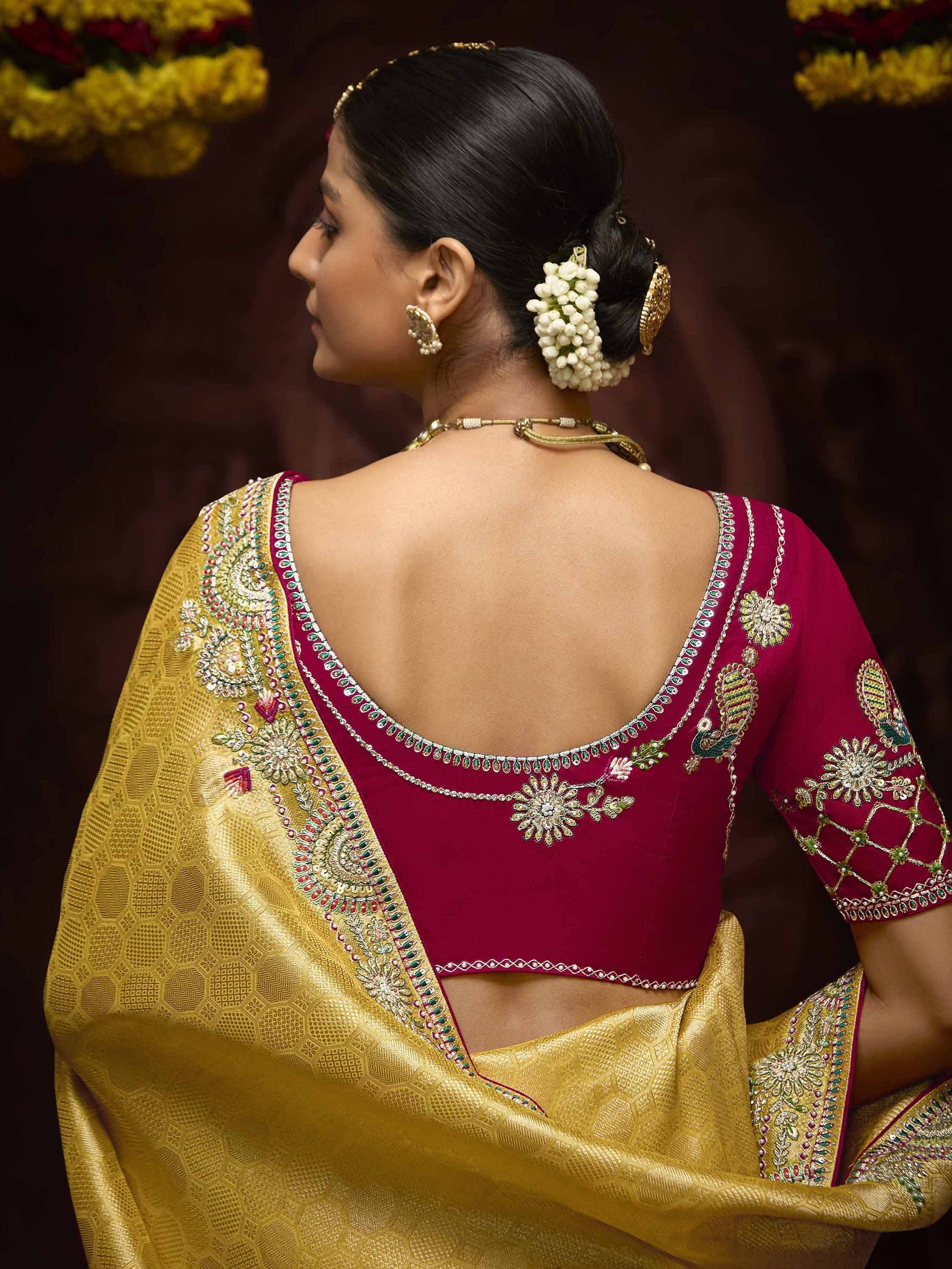 Maroon embroidered blouse with gold saree, floral hair accessory, and traditional Indian jewelry