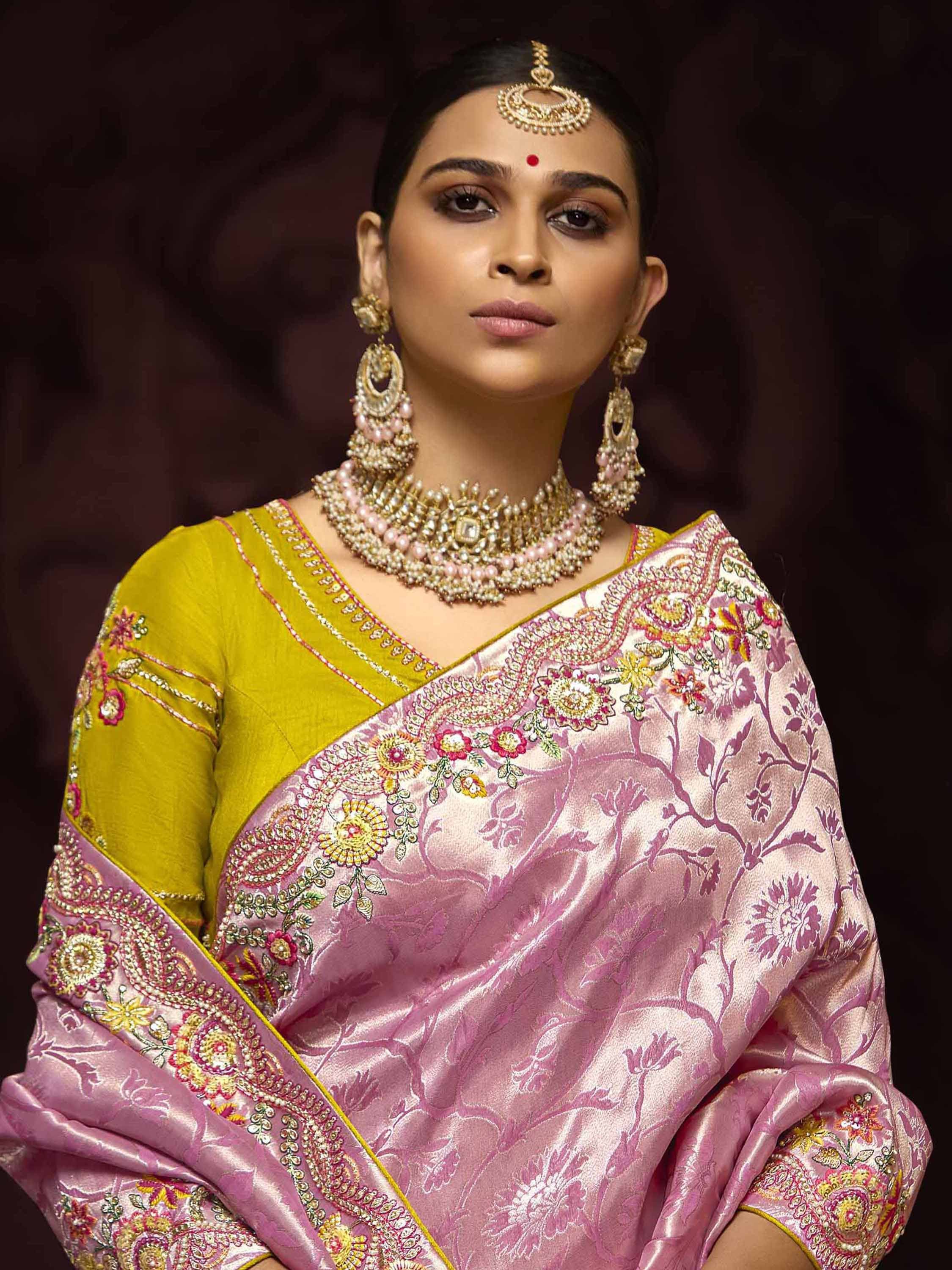 Elegant woman in pink embroidered saree with yellow blouse, traditional Indian jewelry, and maang tikka for festive occasions