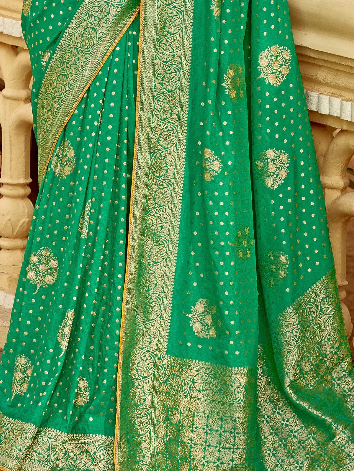 Emerald green saree with gold floral motifs and intricate border, ideal for ethnic occasions