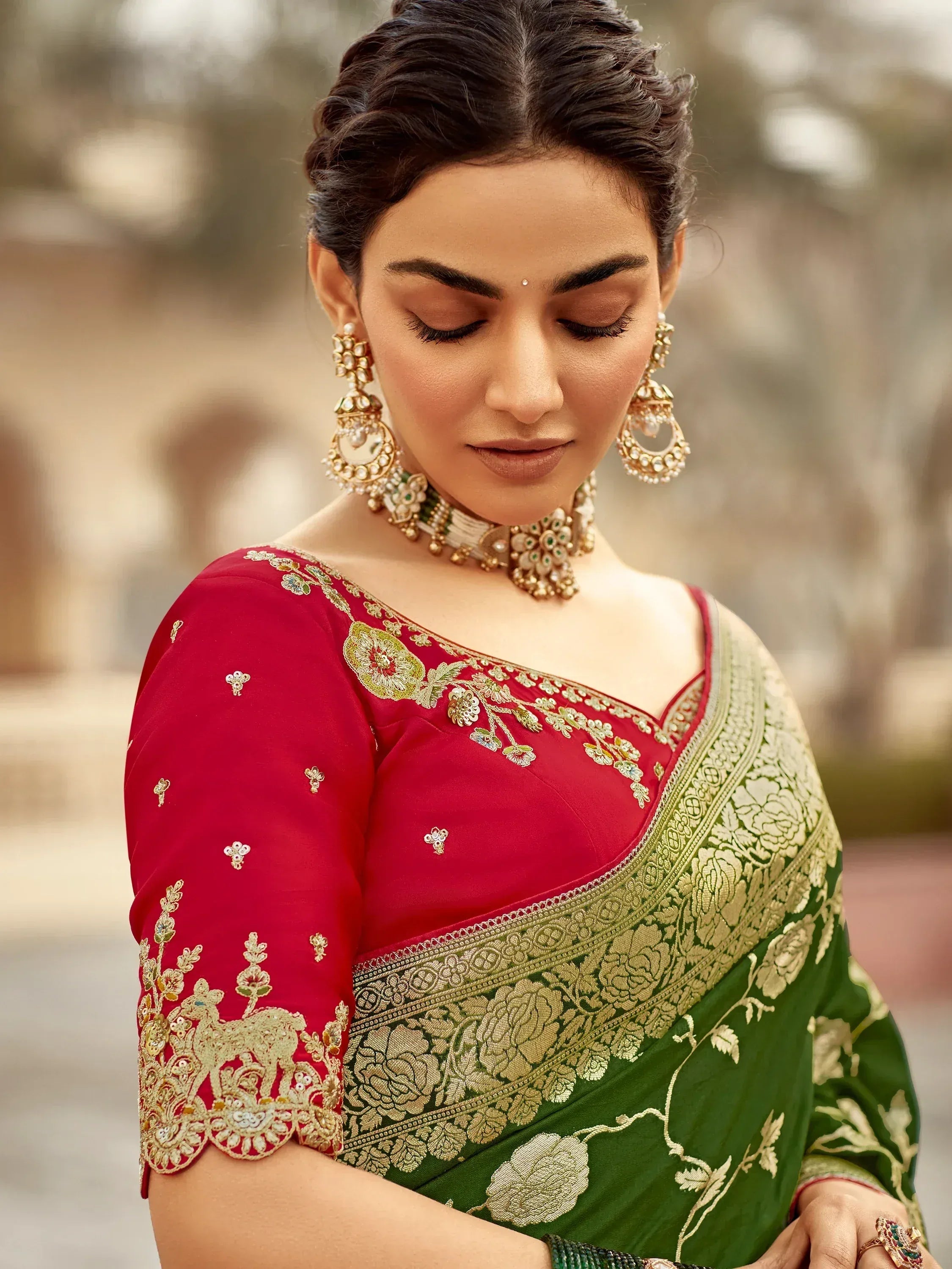 Elegant green and red saree with gold embroidery and matching jewelry