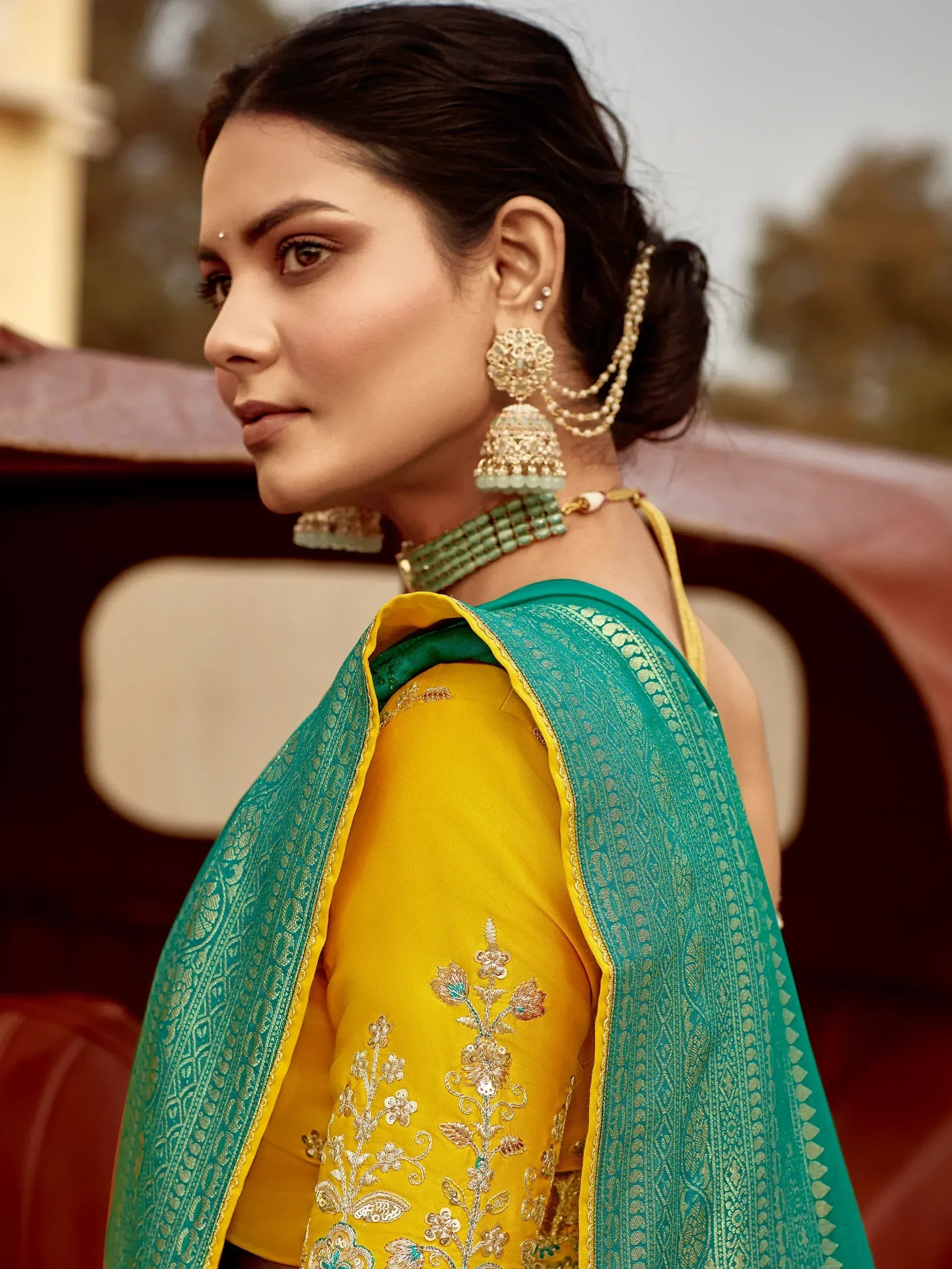 Woman in yellow embroidered blouse with green dupatta, traditional Indian ethnic wear