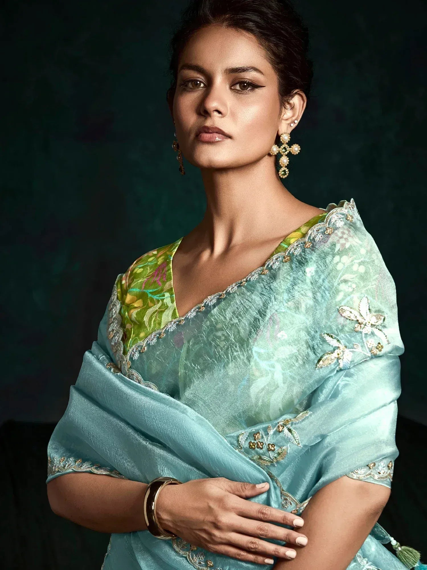 Elegant woman in light blue embroidered saree with green floral blouse, perfect for Indian ethnic occasions.