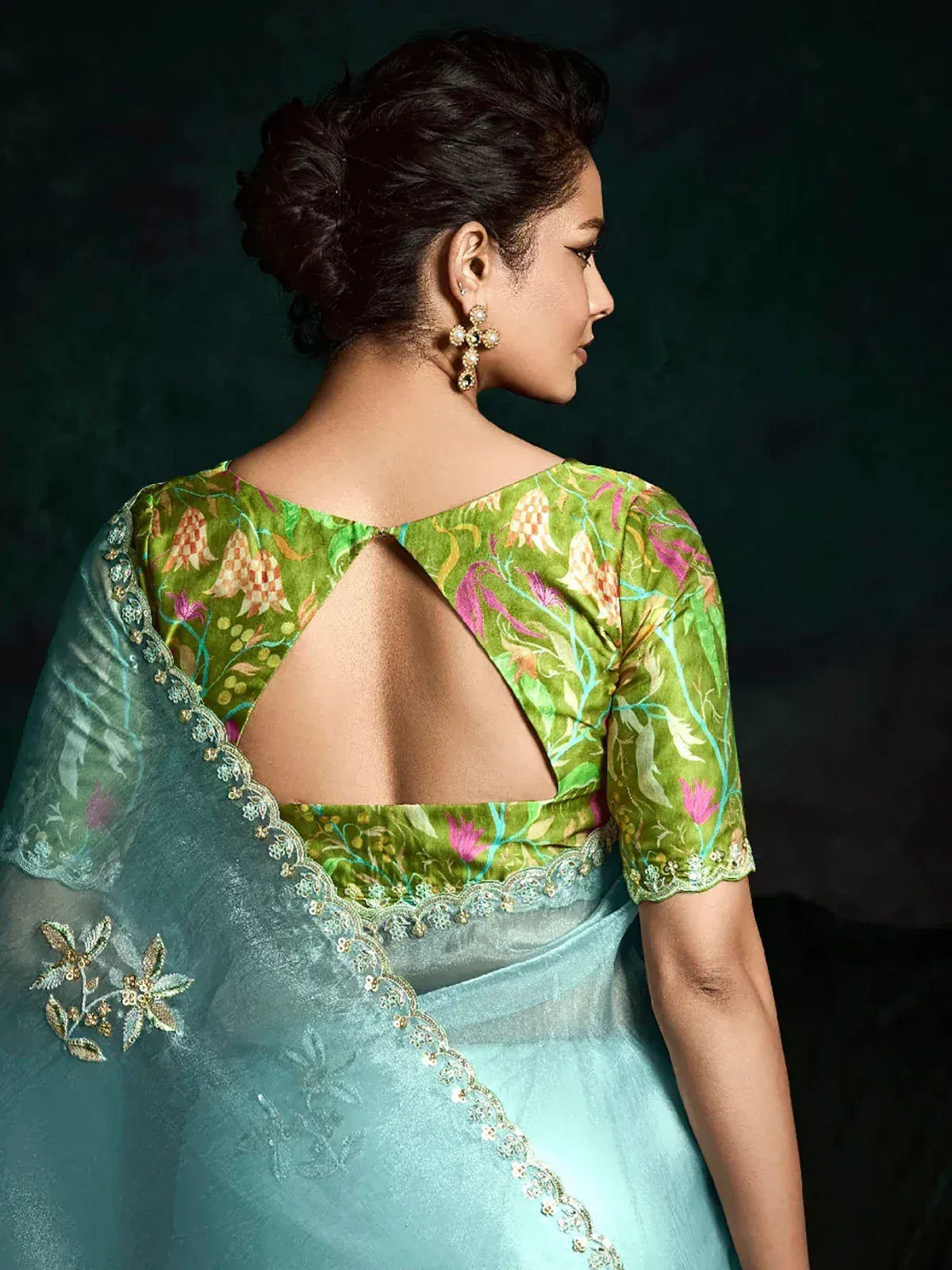 Green floral blouse with back cutout paired with light blue saree, ethnic Indian wear