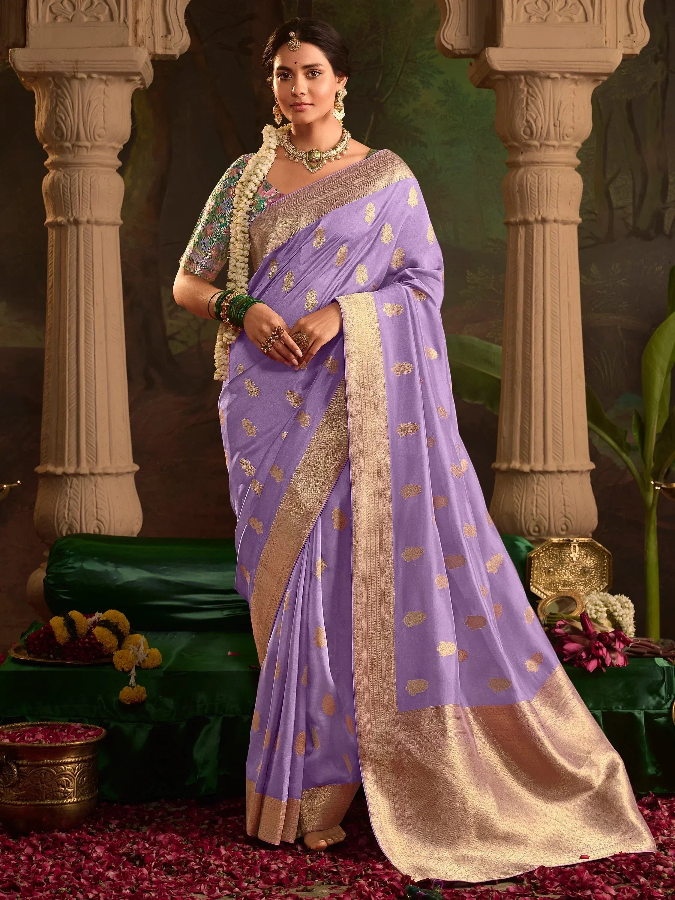 Purple saree with gold motifs and border, styled with traditional jewelry and floral garland