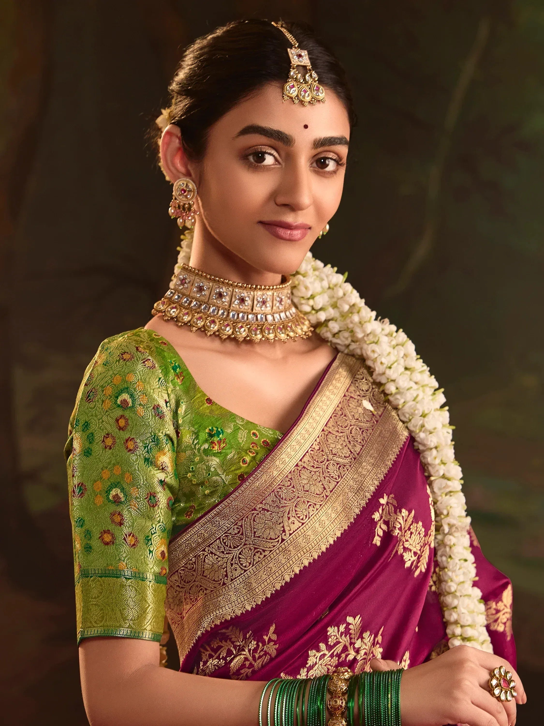 Woman in traditional Indian saree with gold embroidery, floral blouse, and temple jewelry for festive occasions